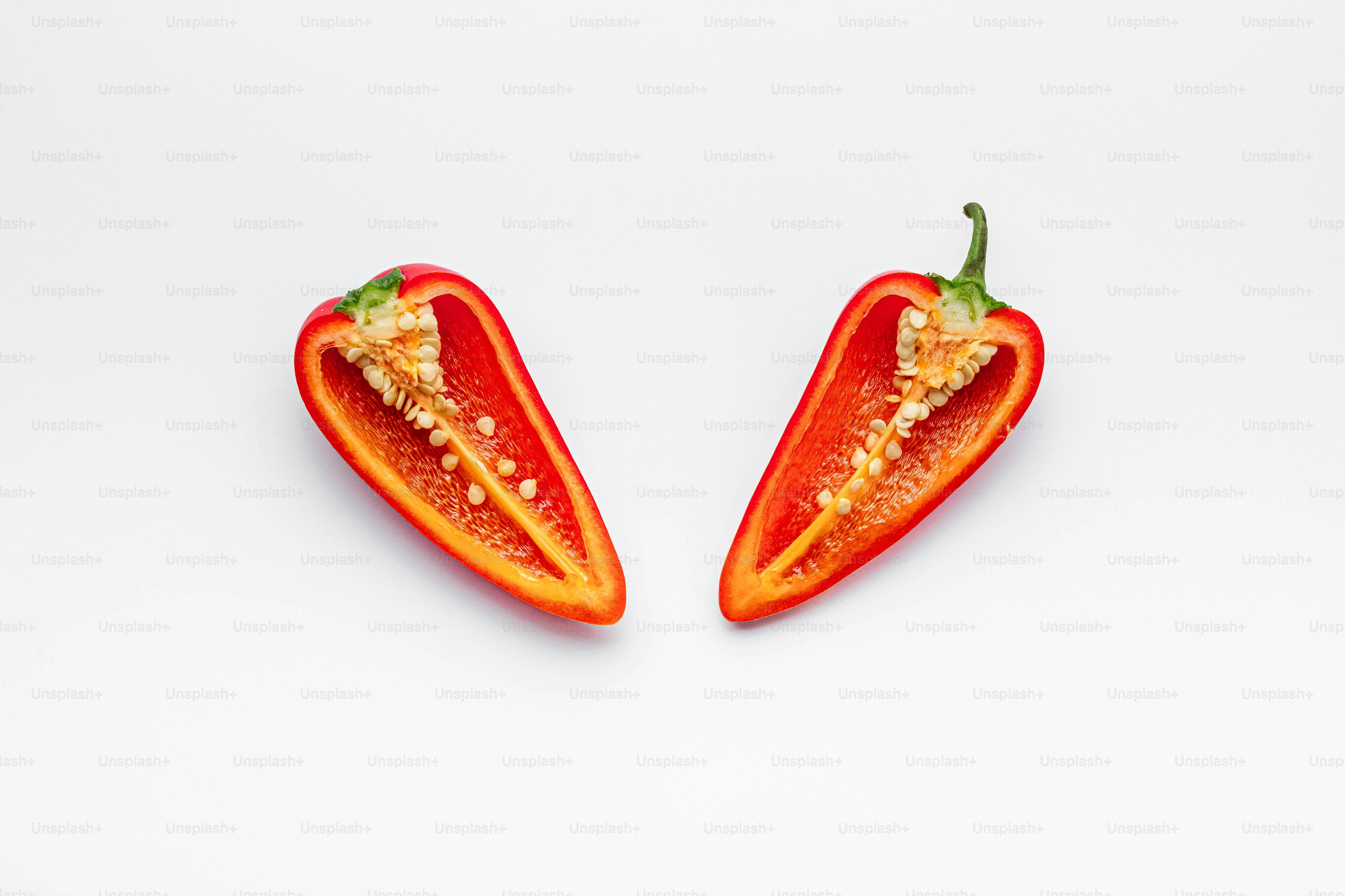 A couple of red peppers sitting on top of a white table