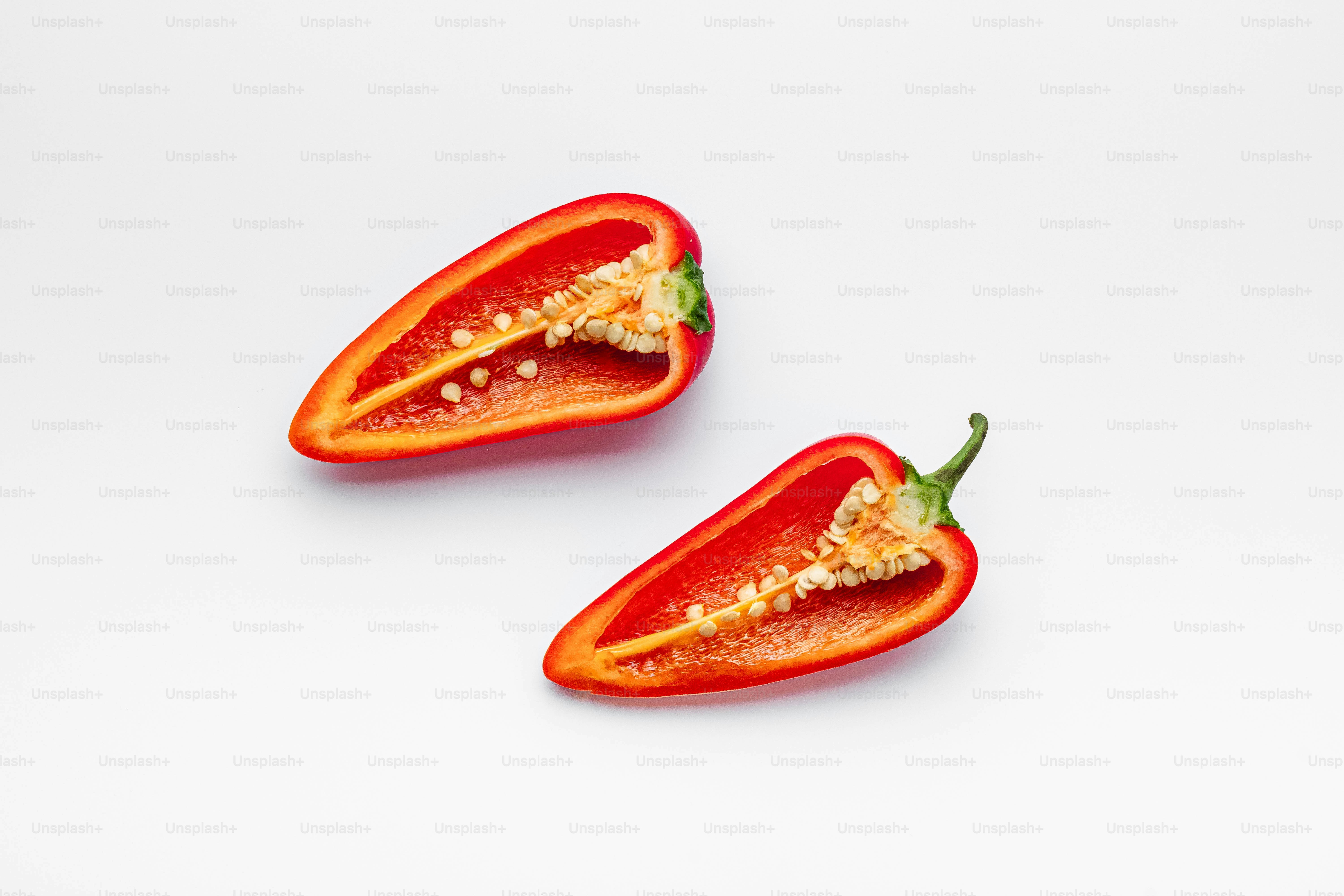 A couple of red peppers sitting on top of a white table