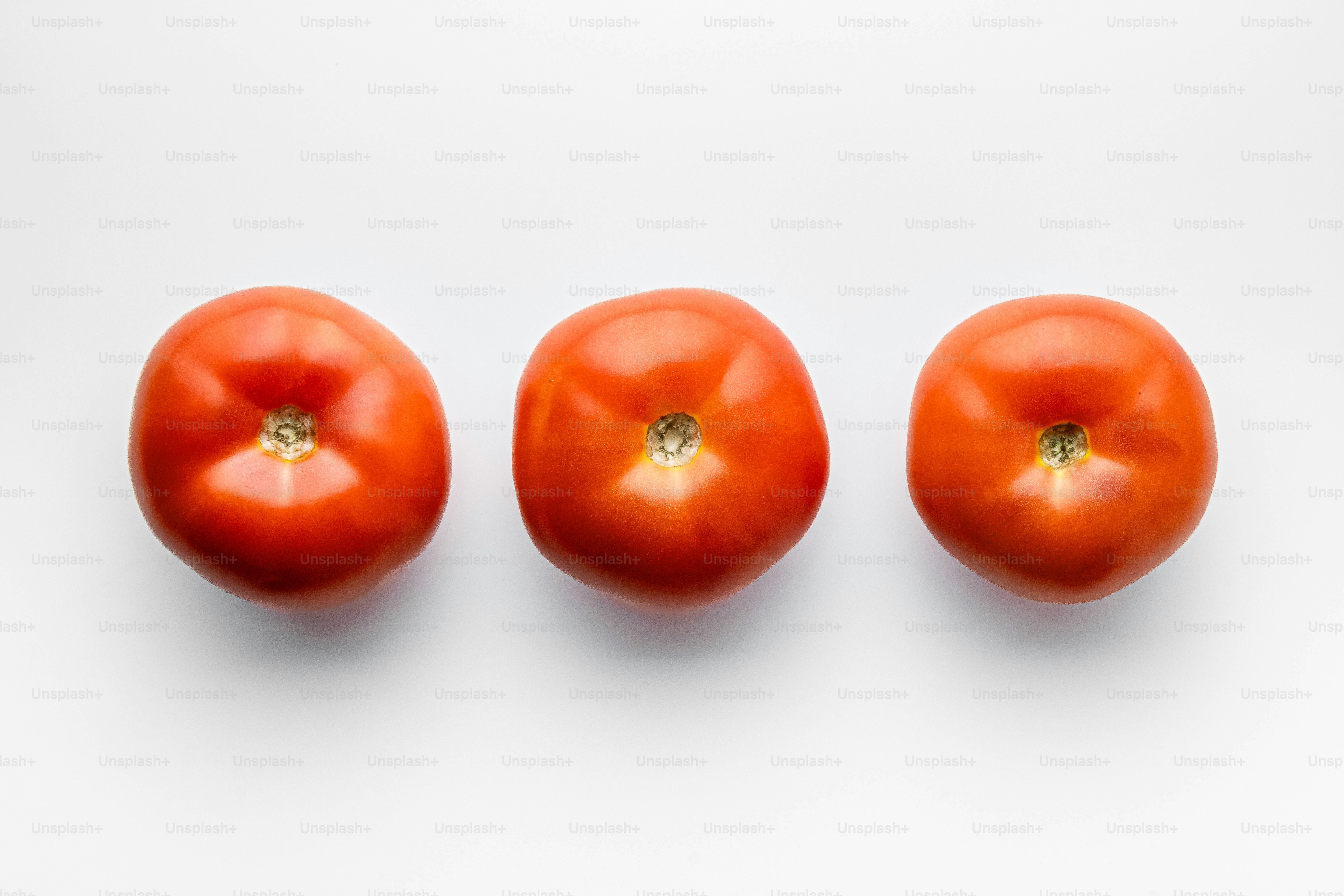 A group of three tomatoes sitting next to each other