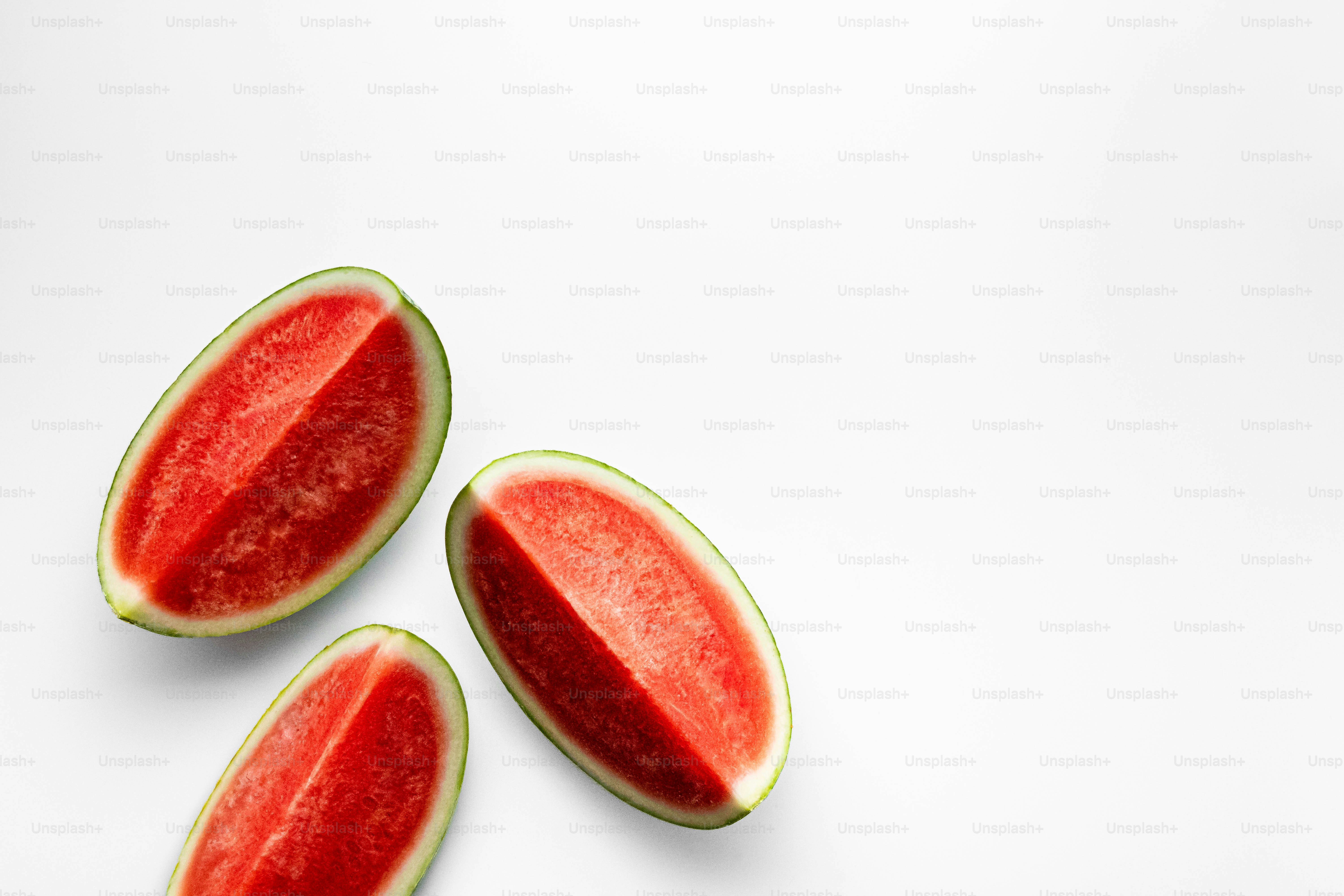 Three slices of watermelon on a white surface