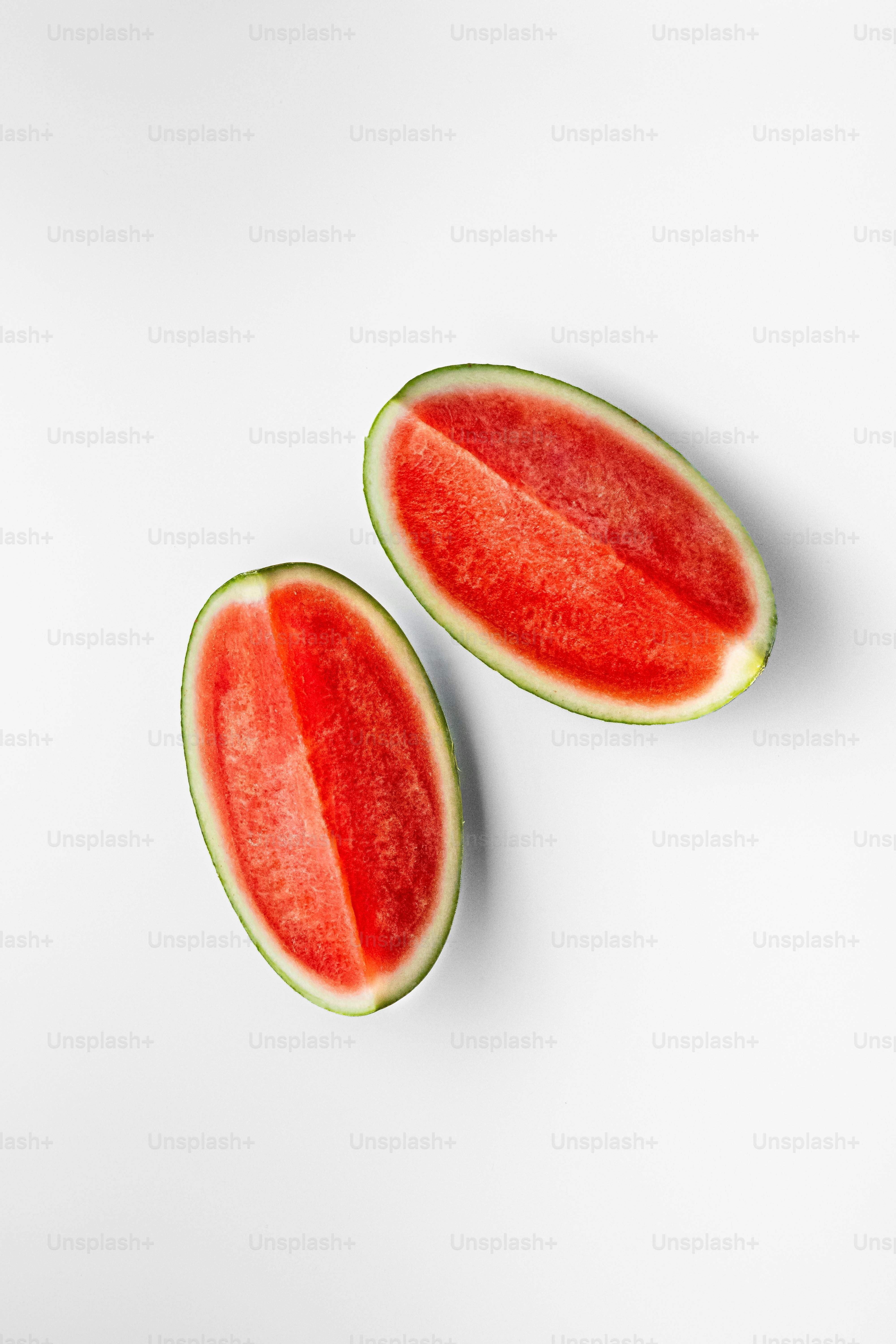 Two pieces of watermelon on a white surface