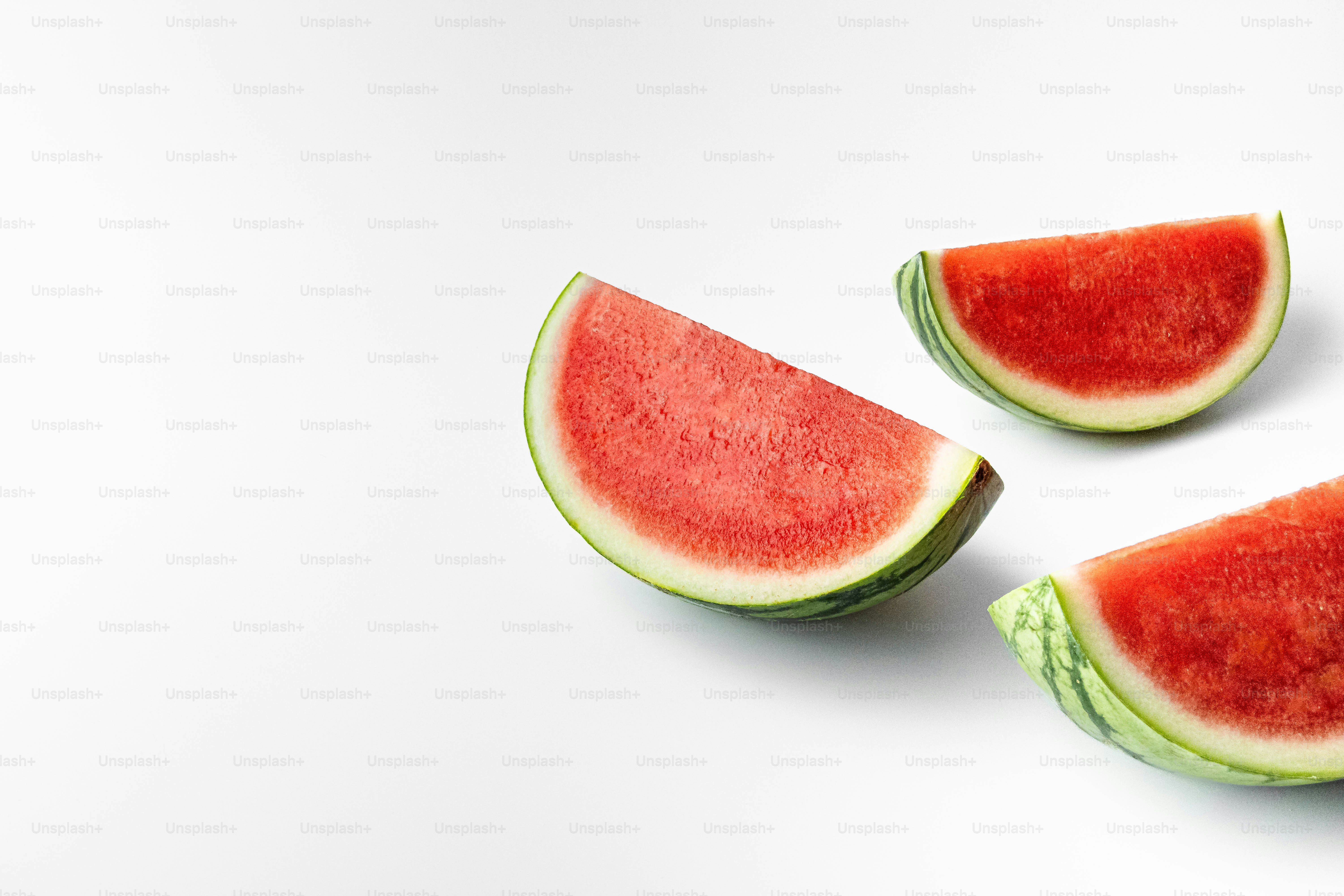 A group of slices of watermelon on a white background