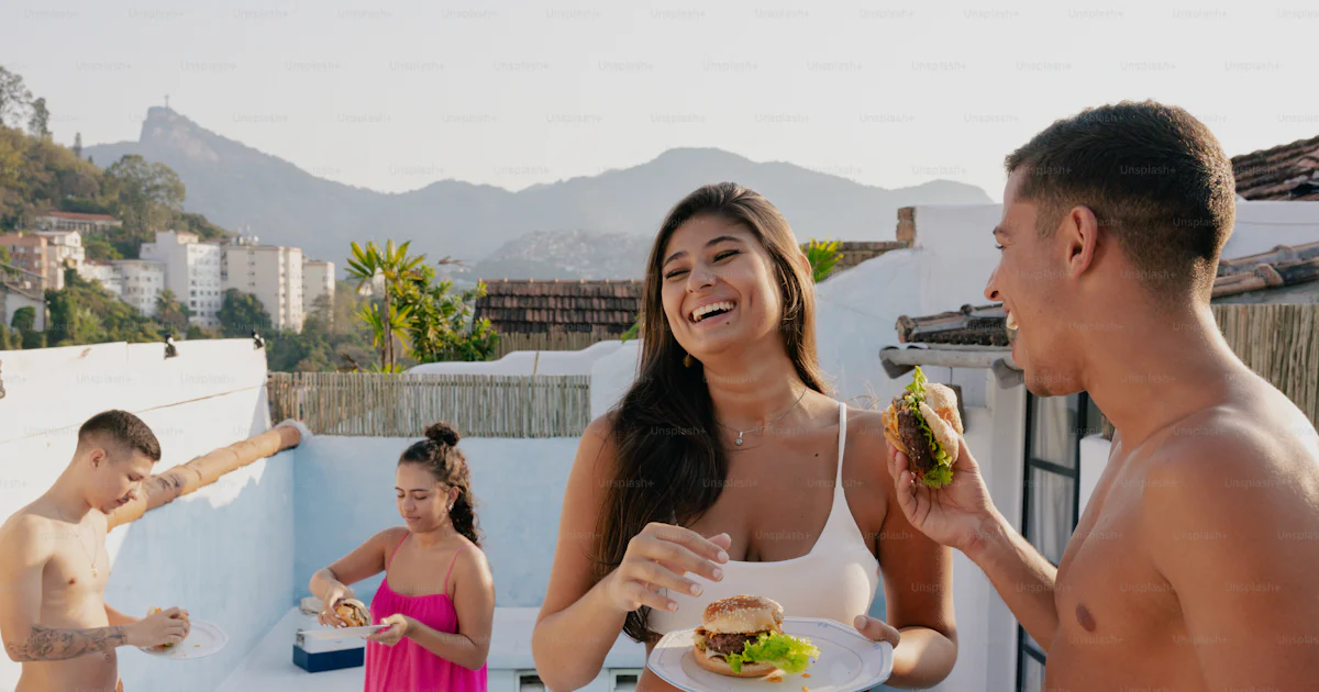 Eating In The Pool A group of people standing around a pool eating food photo – Food Image ...