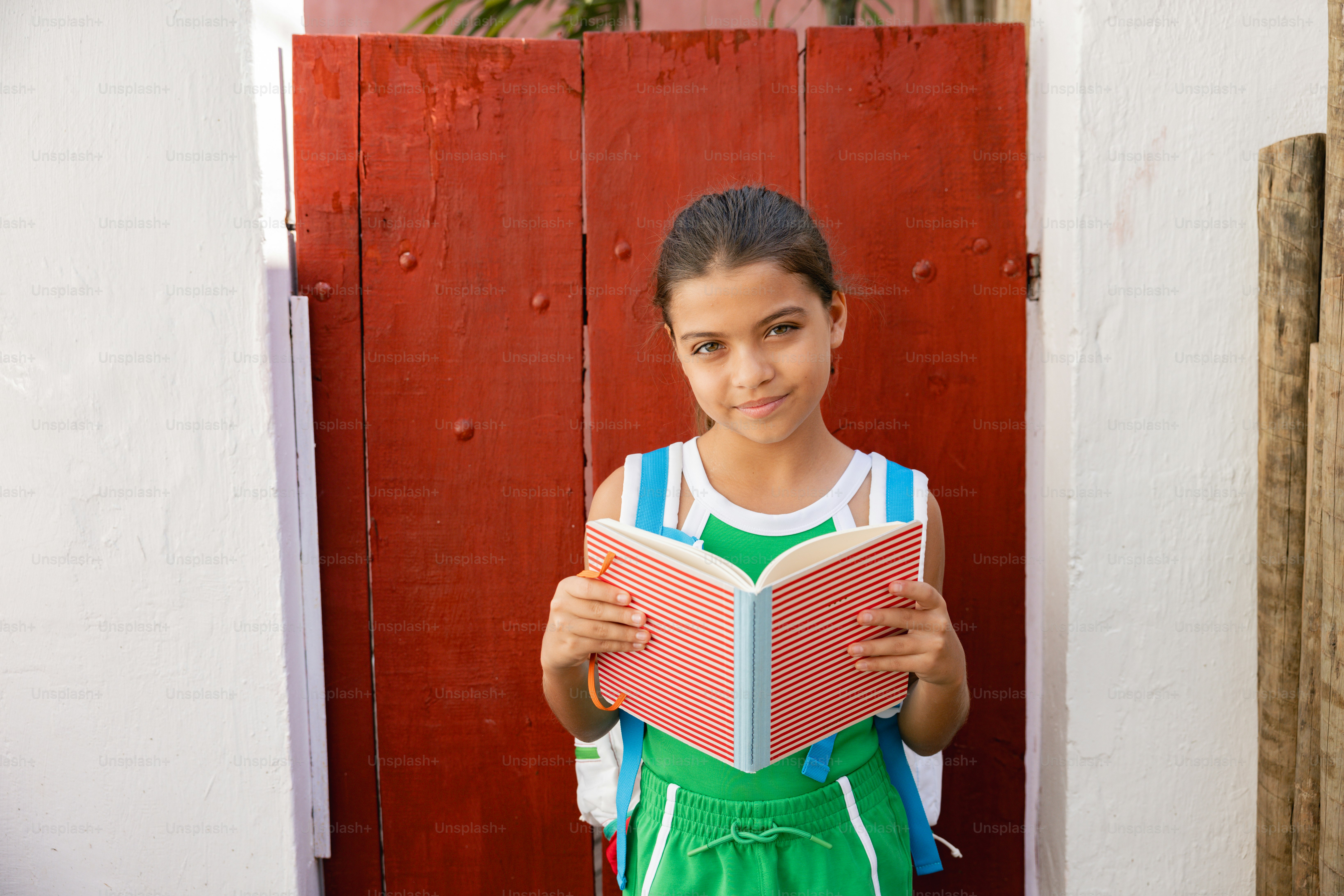 A young girl is holding a book in her hands photo – Fashion Image on ...