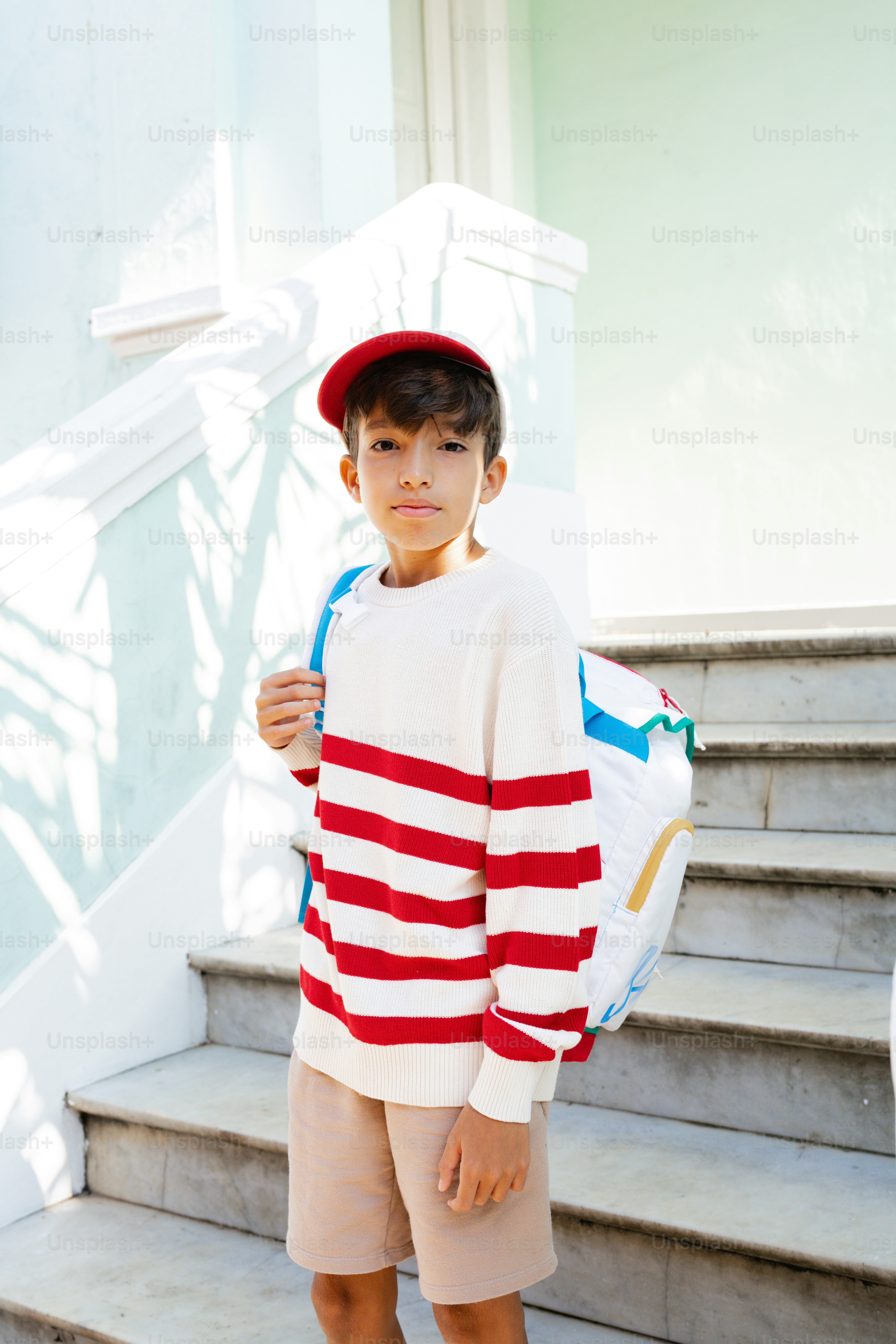 Un niño vestido con un suéter de rayas rojas y blancas