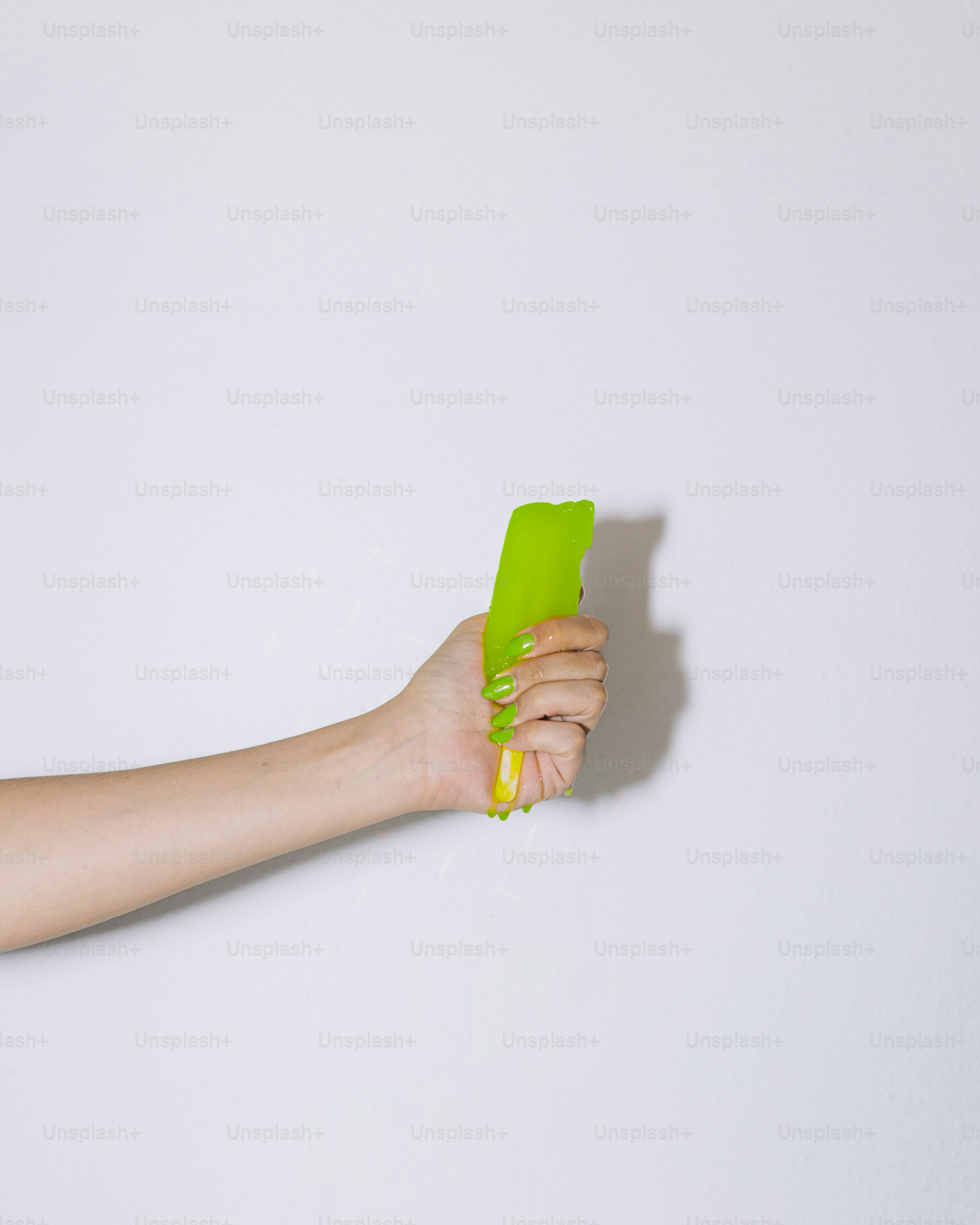A woman holding a green object in her hand