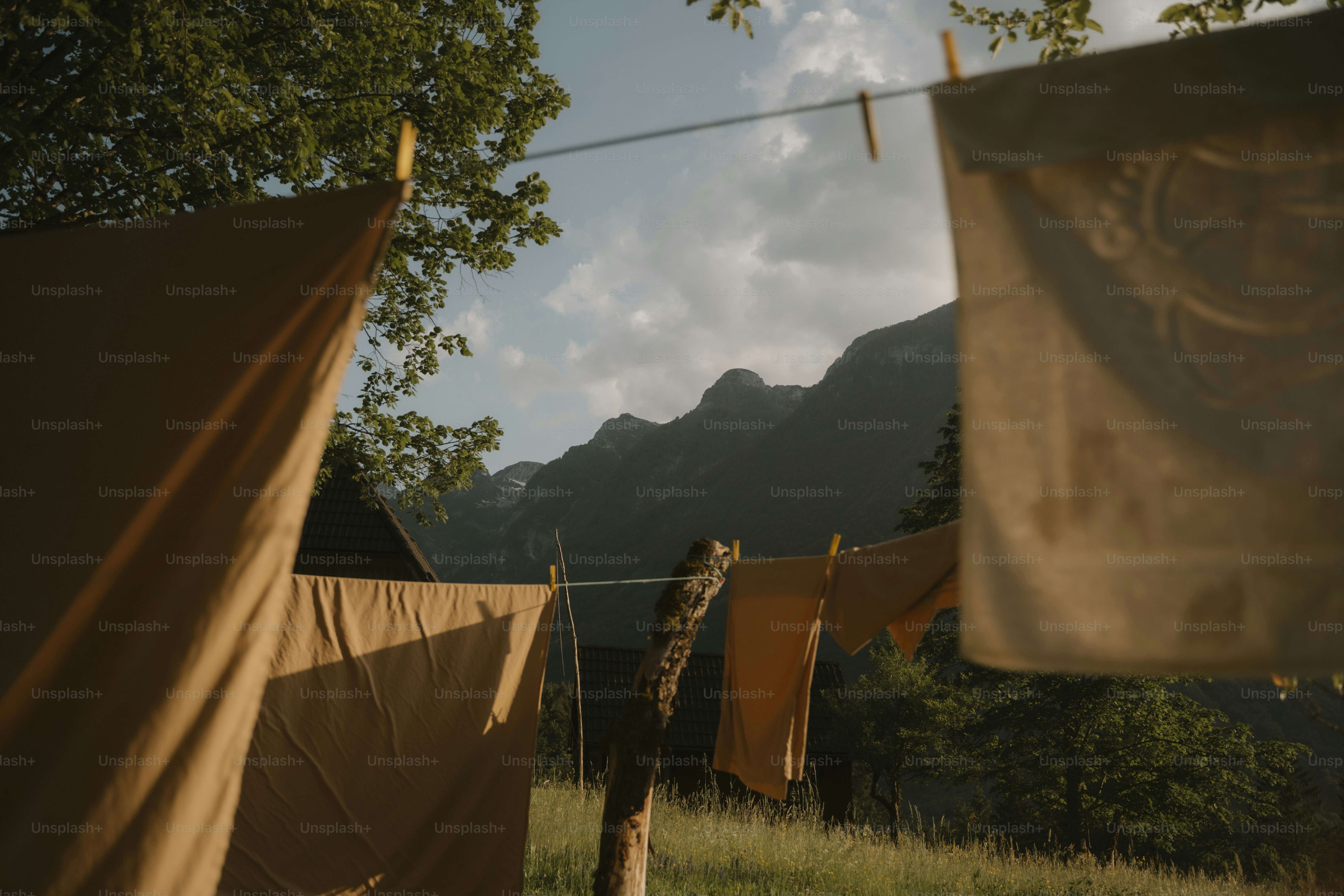 A couple of brown tents sitting on top of a lush green field