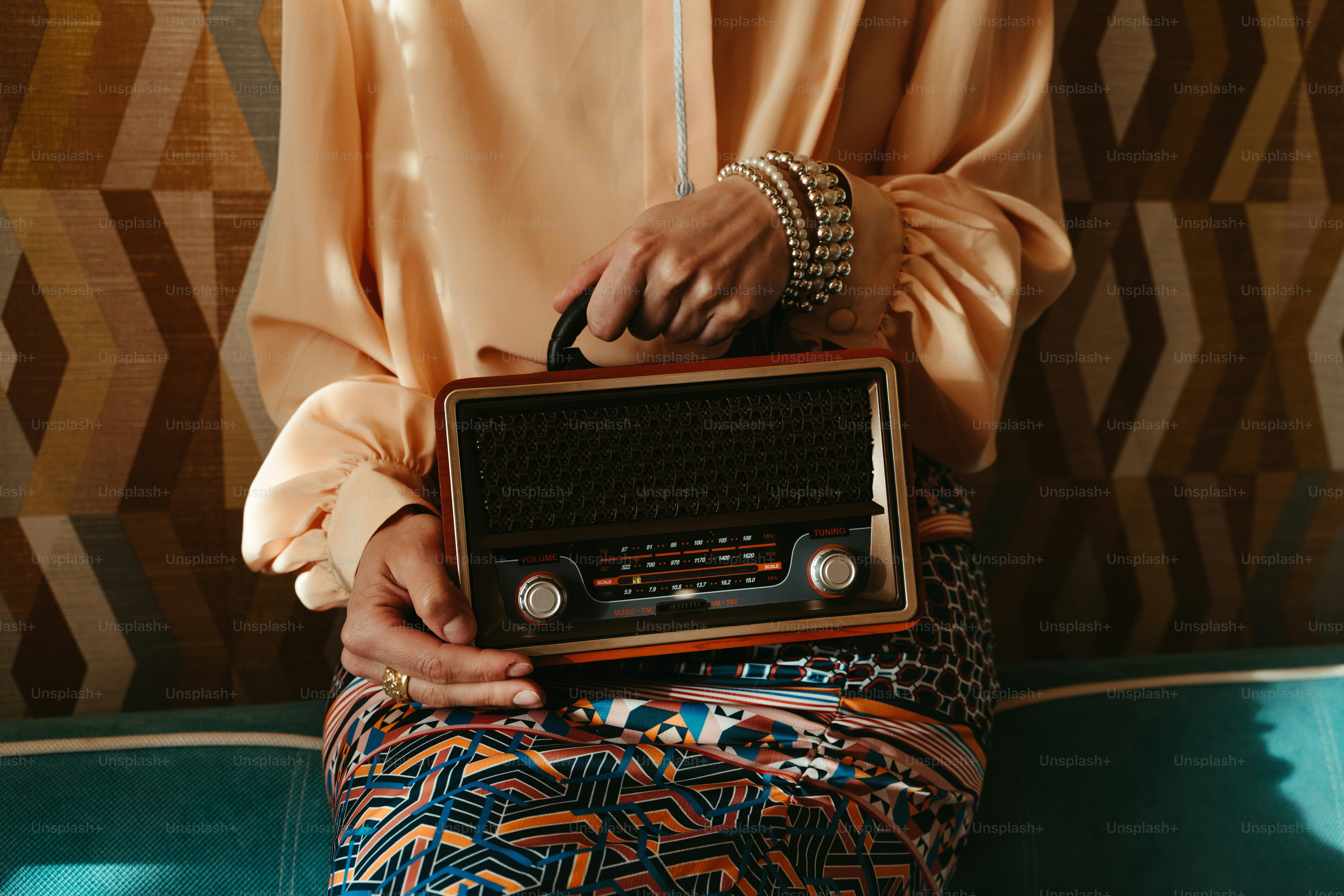 A woman sitting on a couch holding a radio