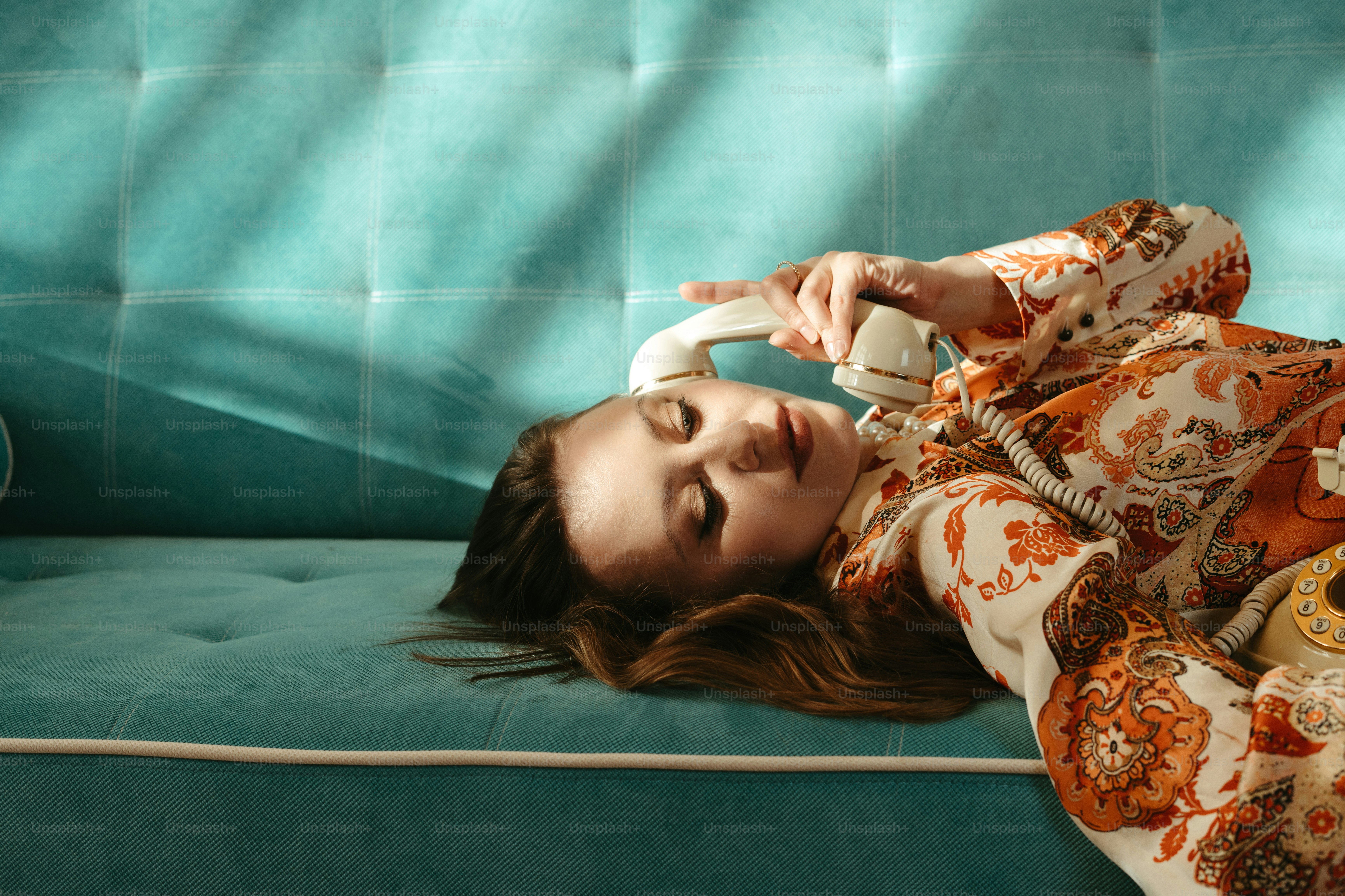 A woman laying on top of a blue couch