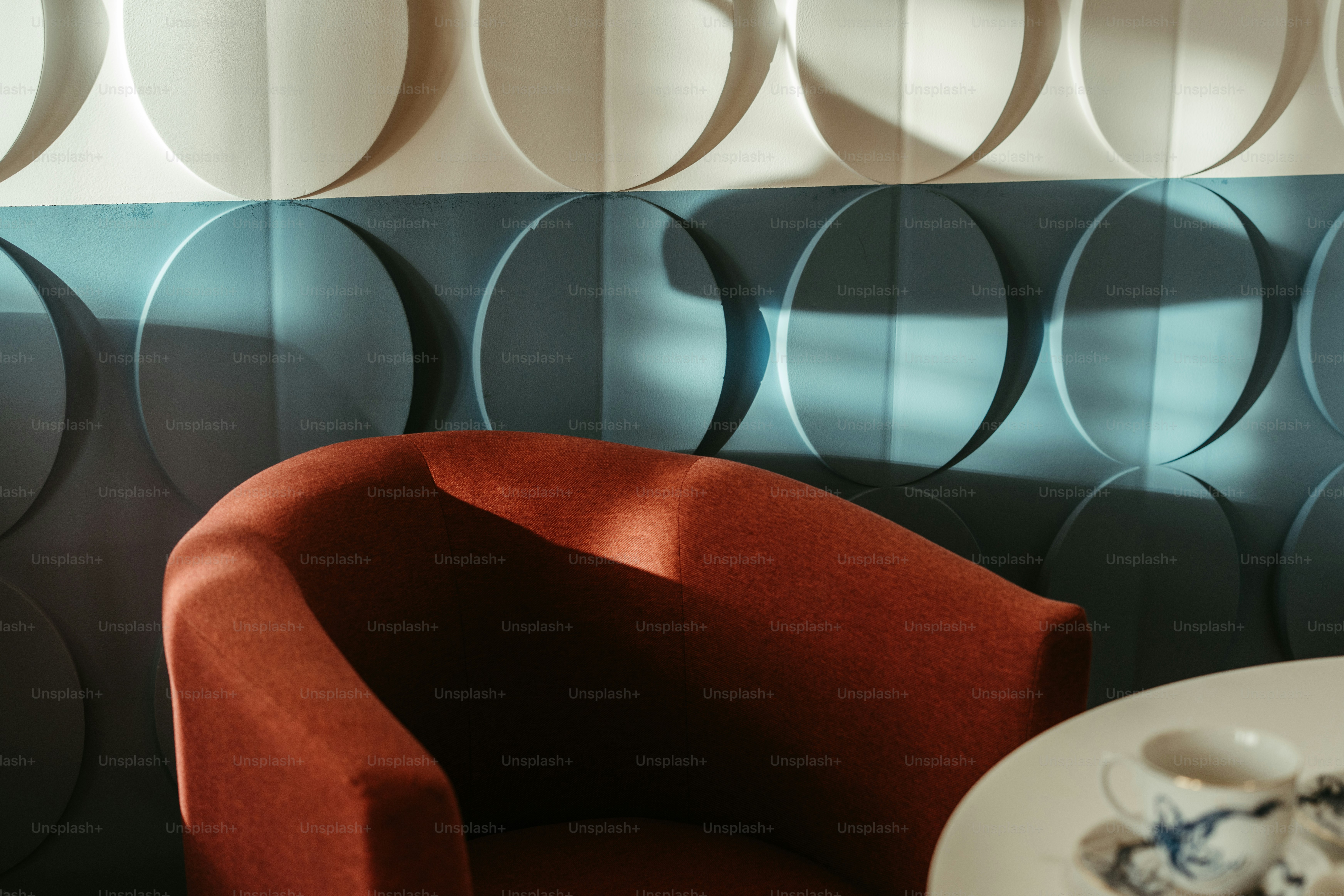 A red chair sitting next to a white table