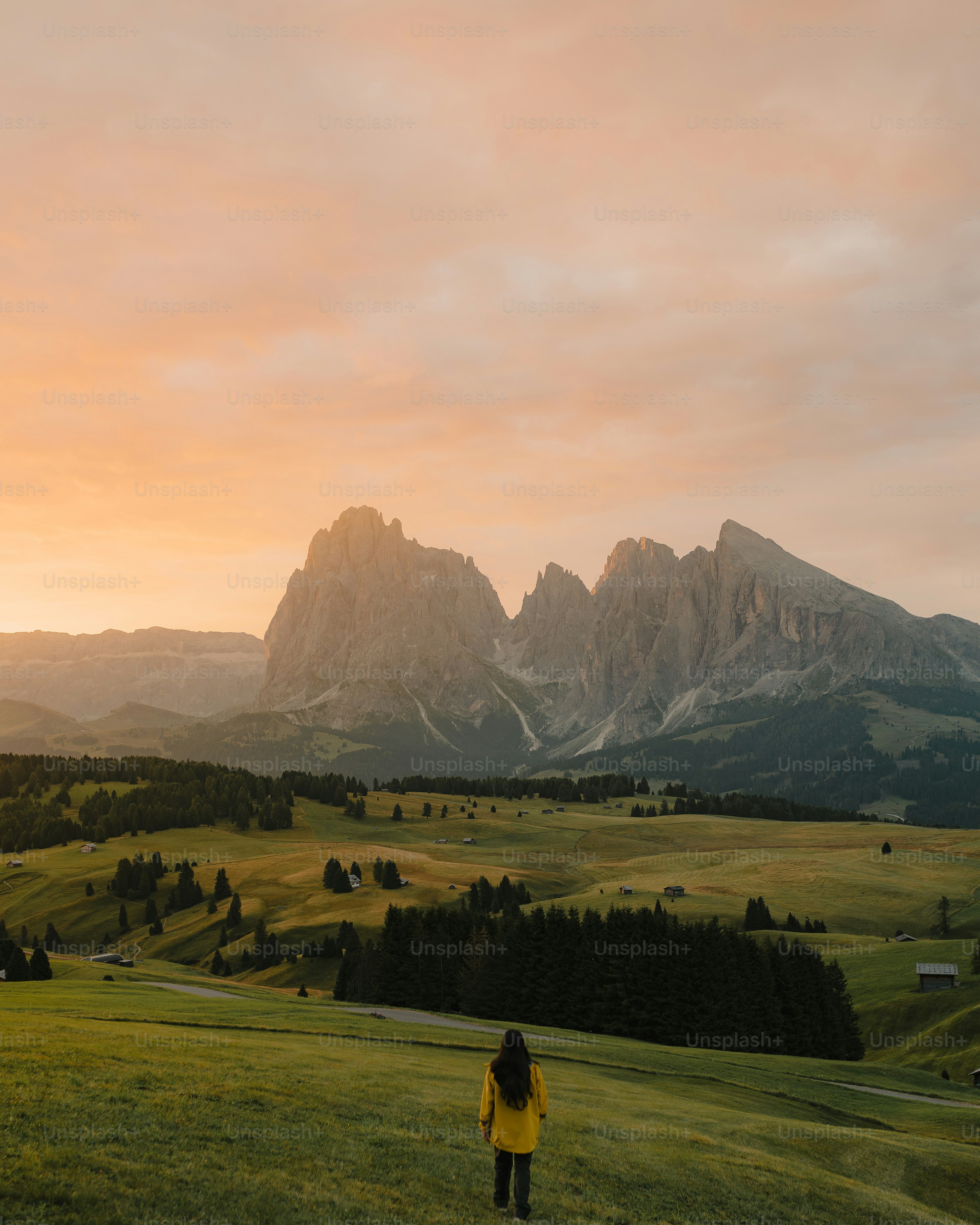 A woman standing on top of a lush green hillside