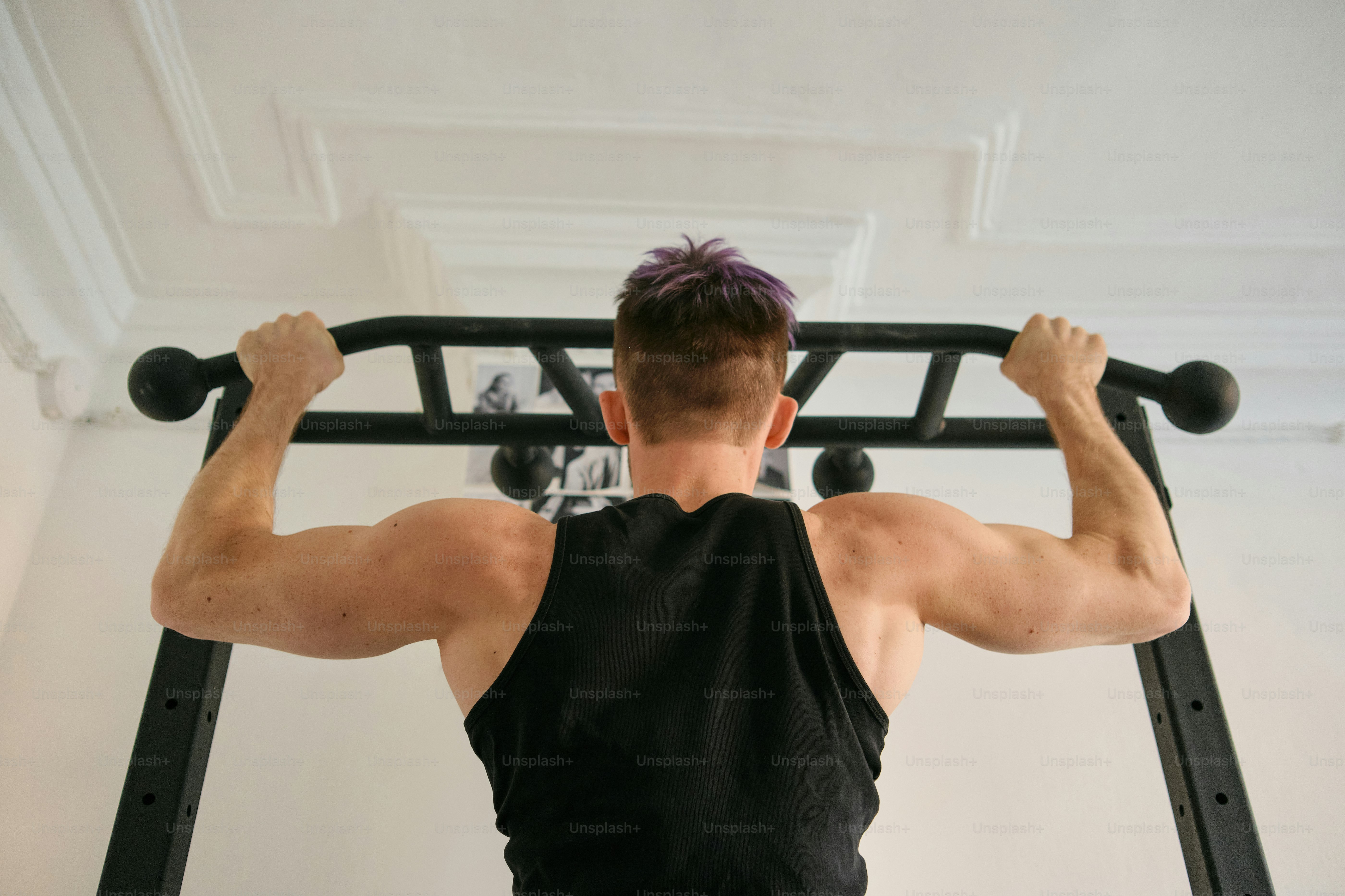 A man doing a pull up on a pull up bar