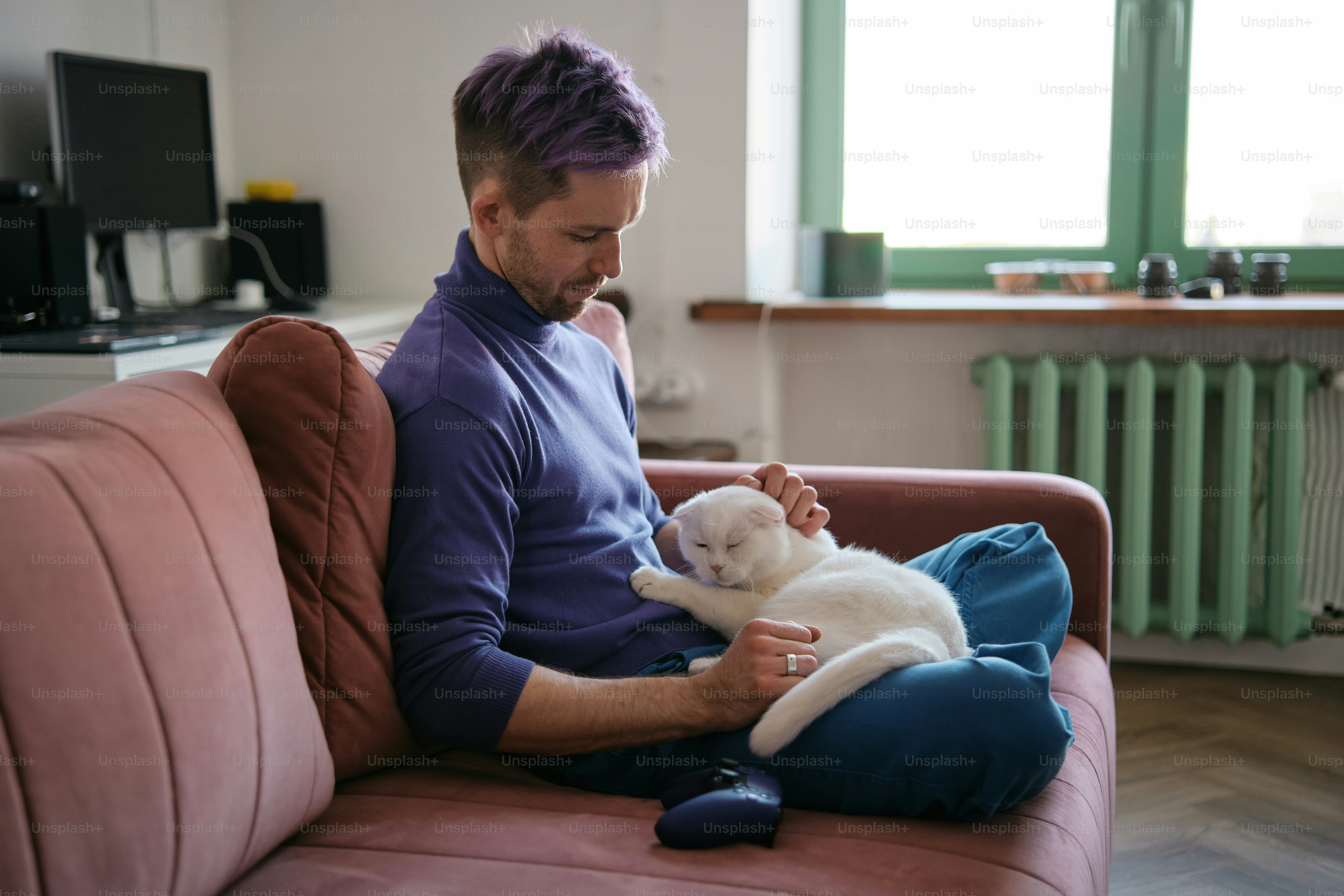 A man sitting on a couch holding a cat