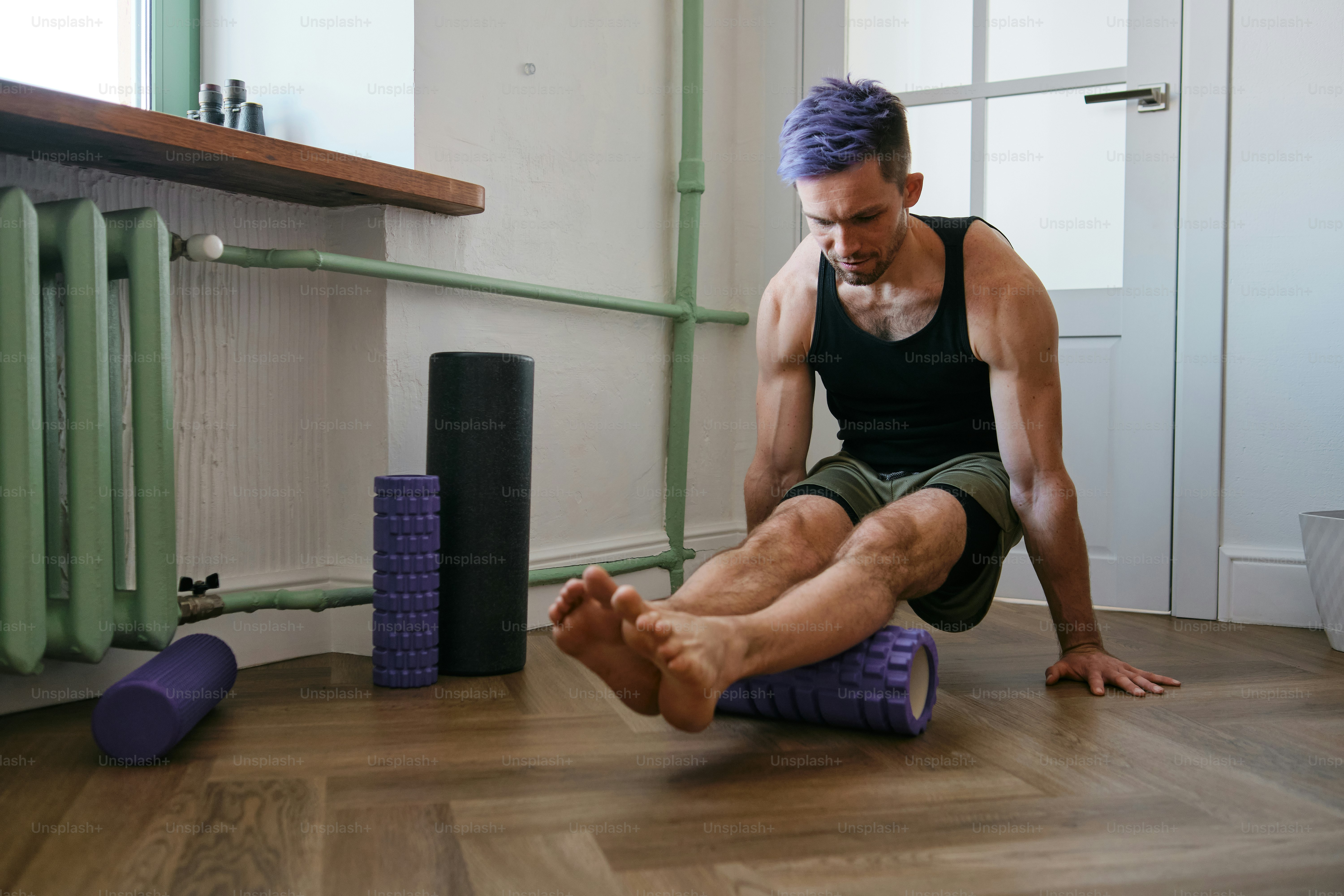 A man sitting on a yoga mat in a room