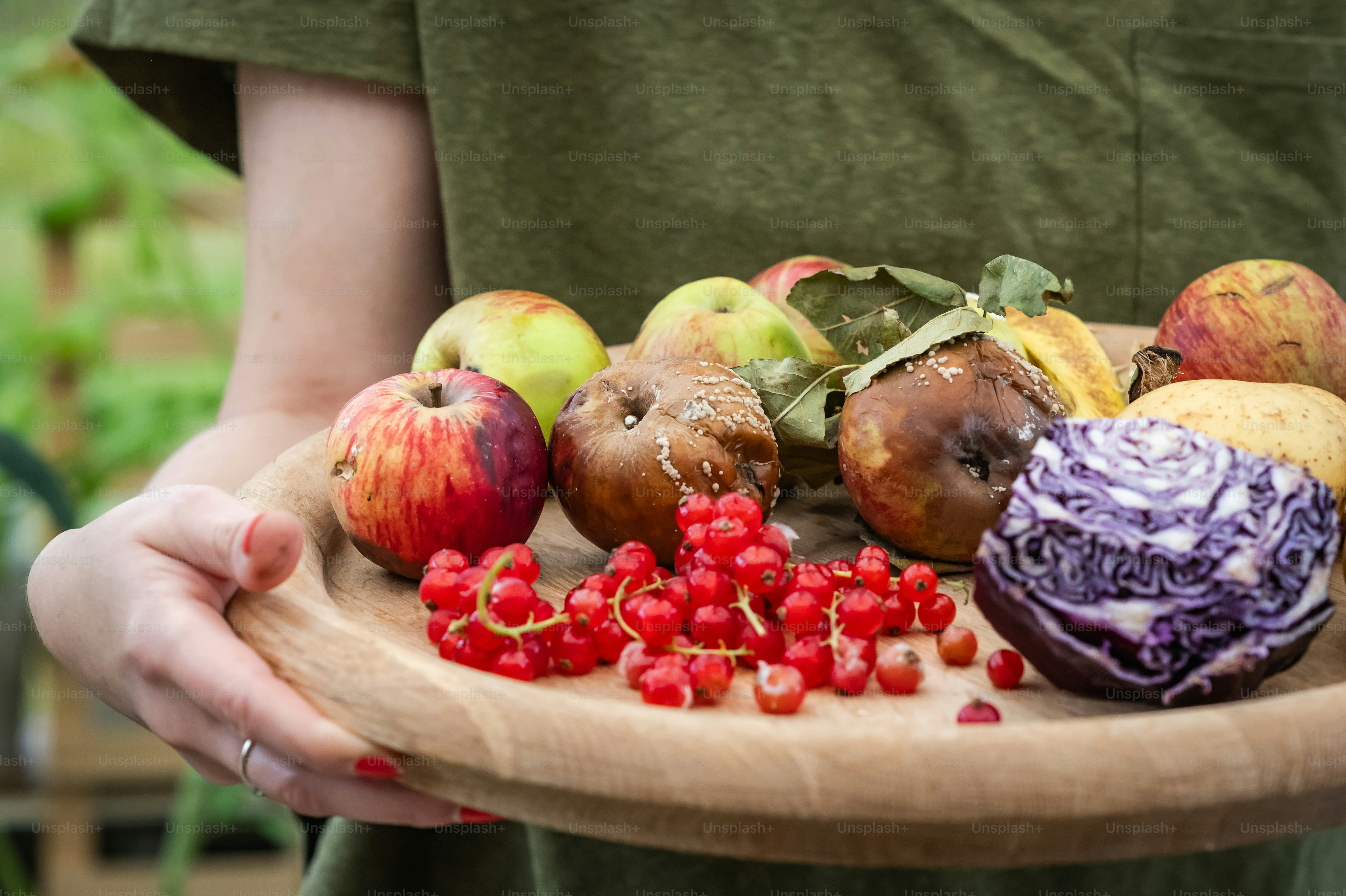 A person holding a plate of fruit and vegetables