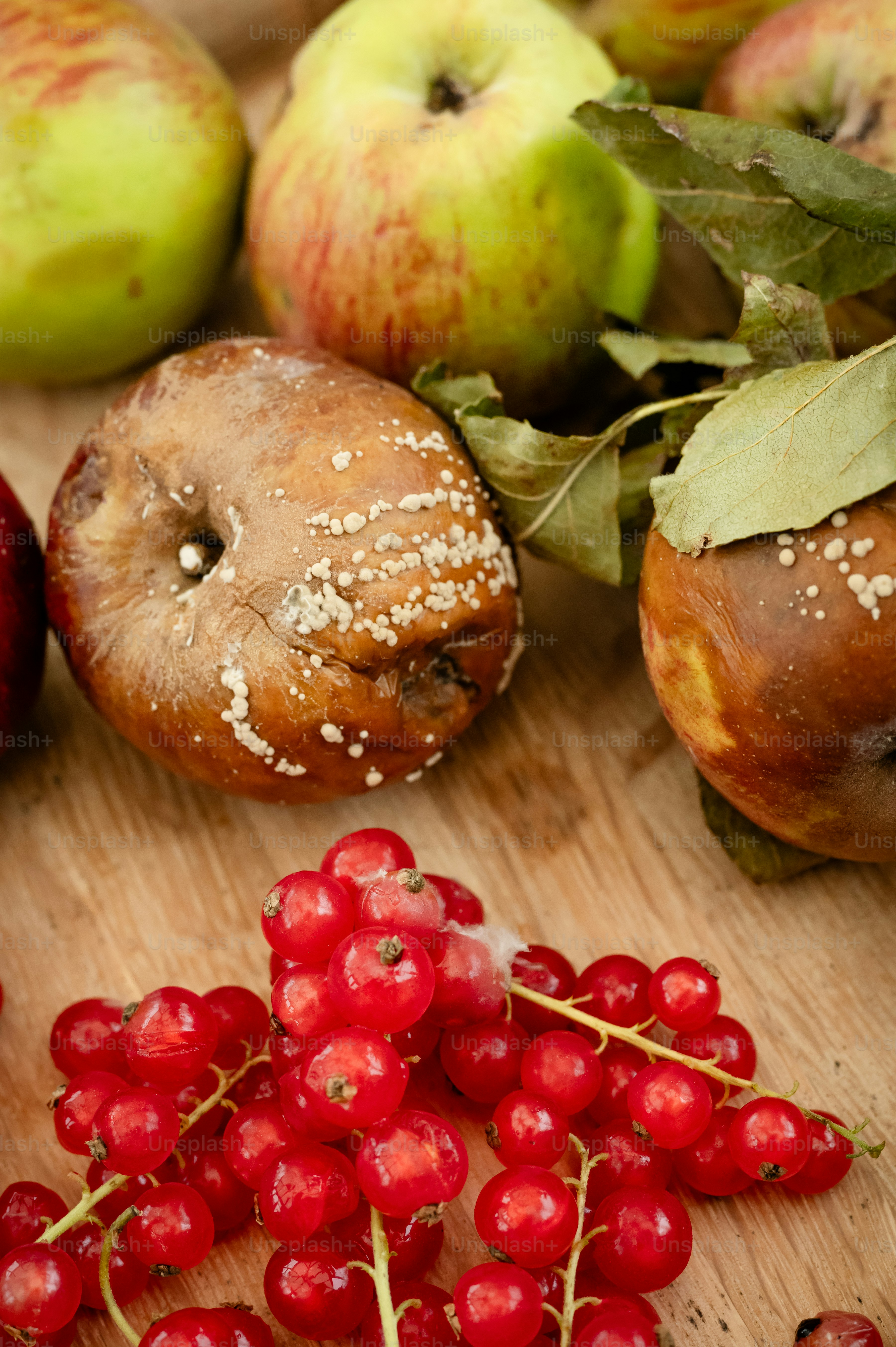 A wooden cutting board topped with apples and berries