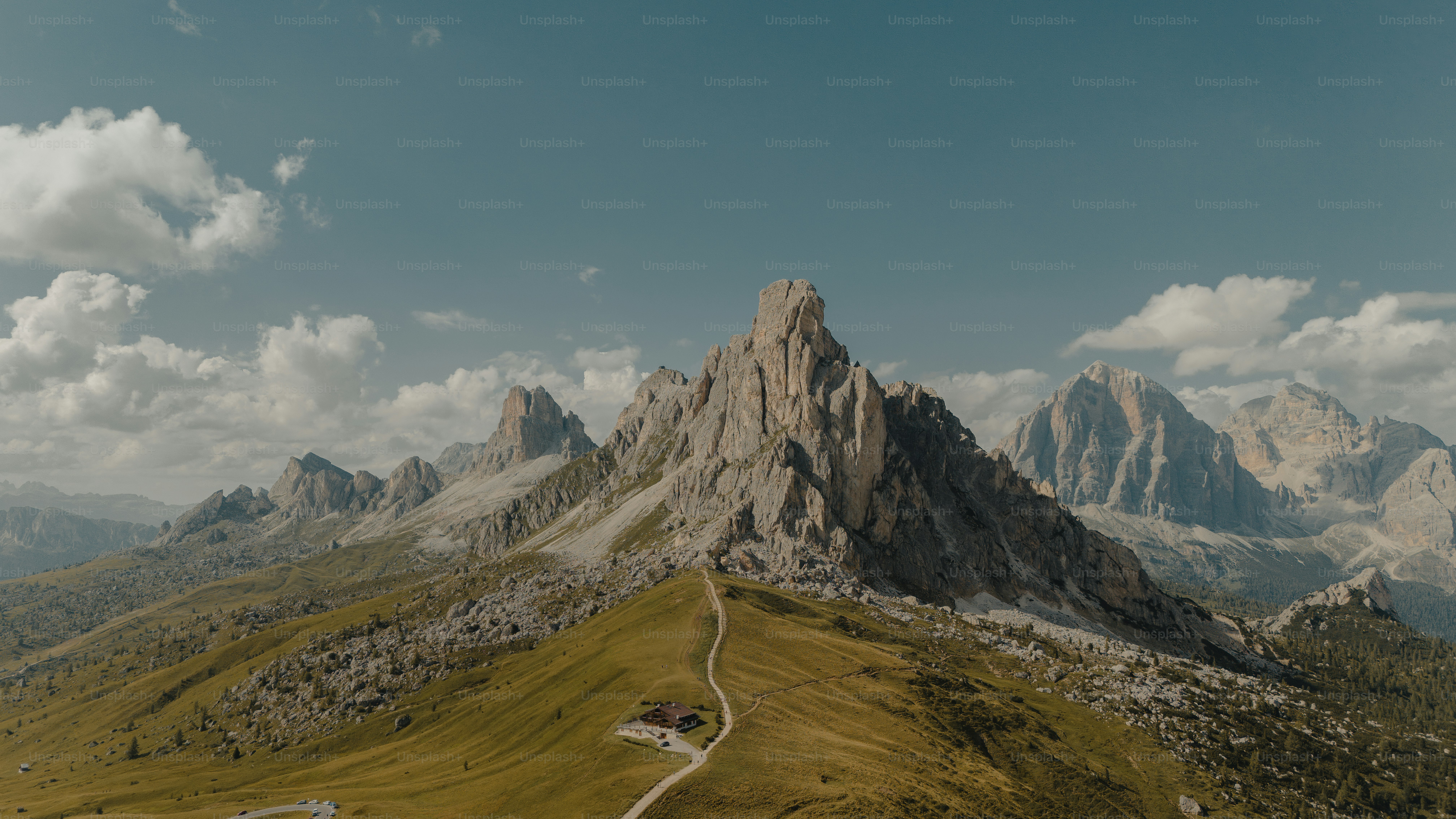 An aerial view of a mountain with a winding road in the foreground