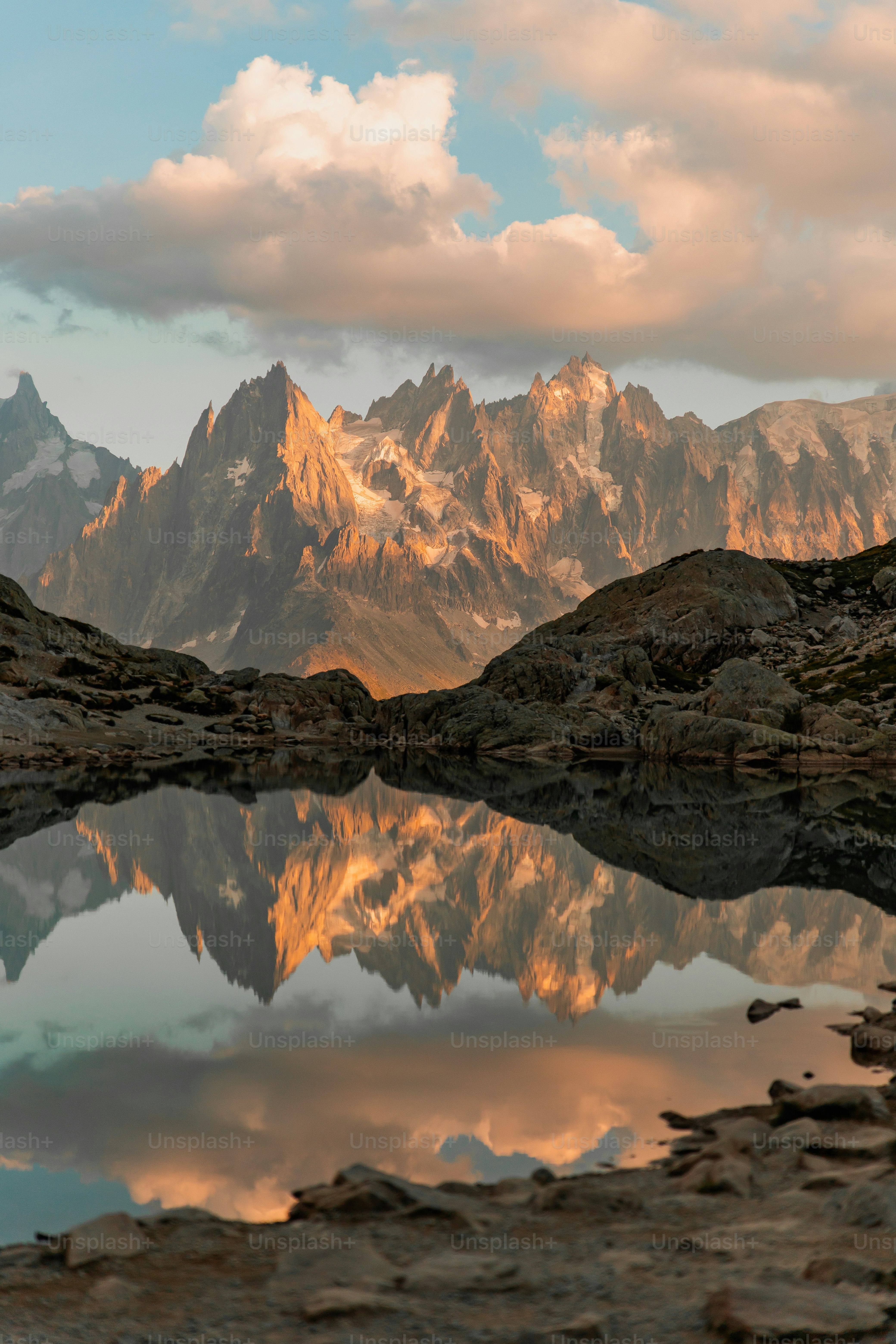 A mountain range is reflected in the still water of a lake