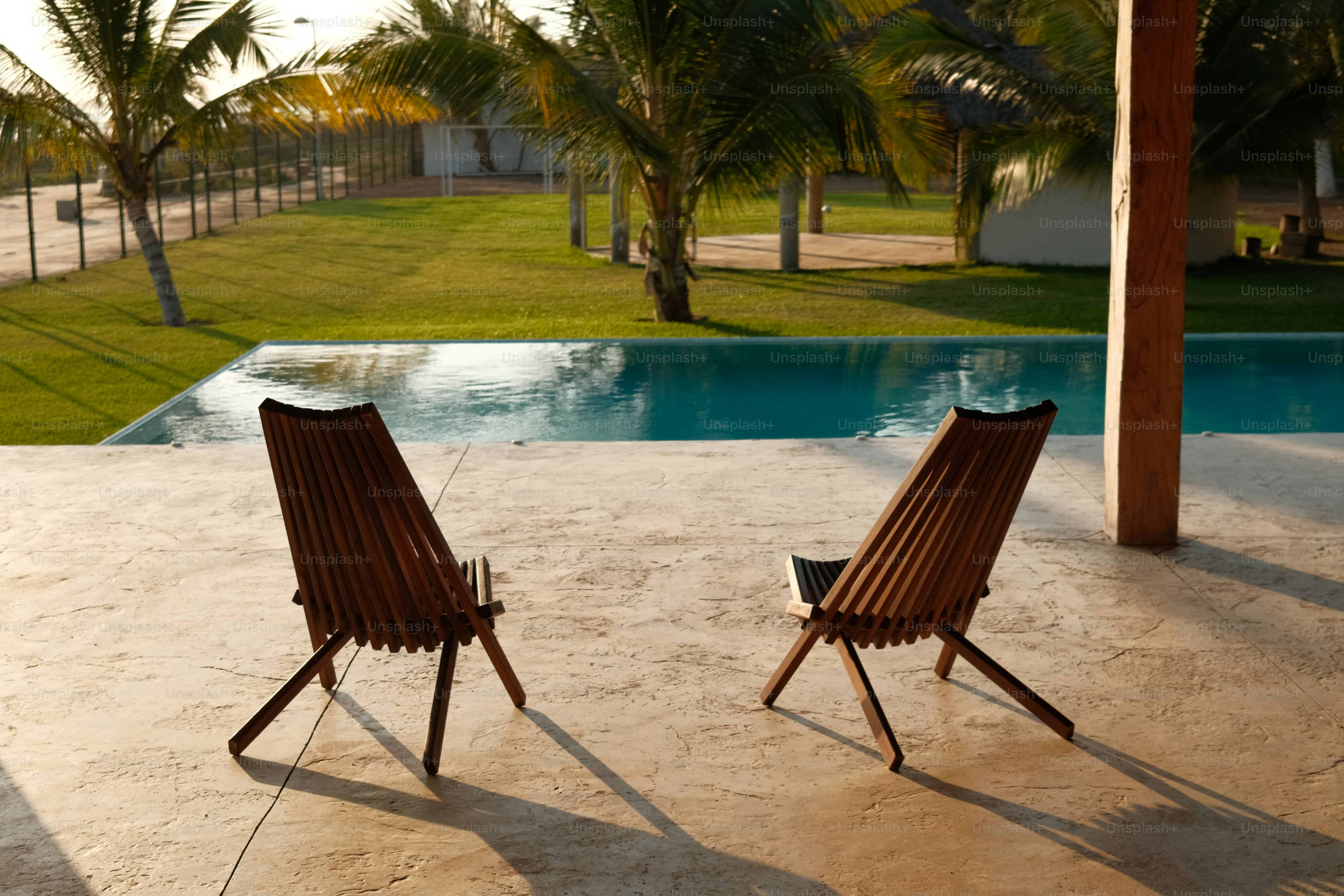 A couple of chairs sitting next to a swimming pool