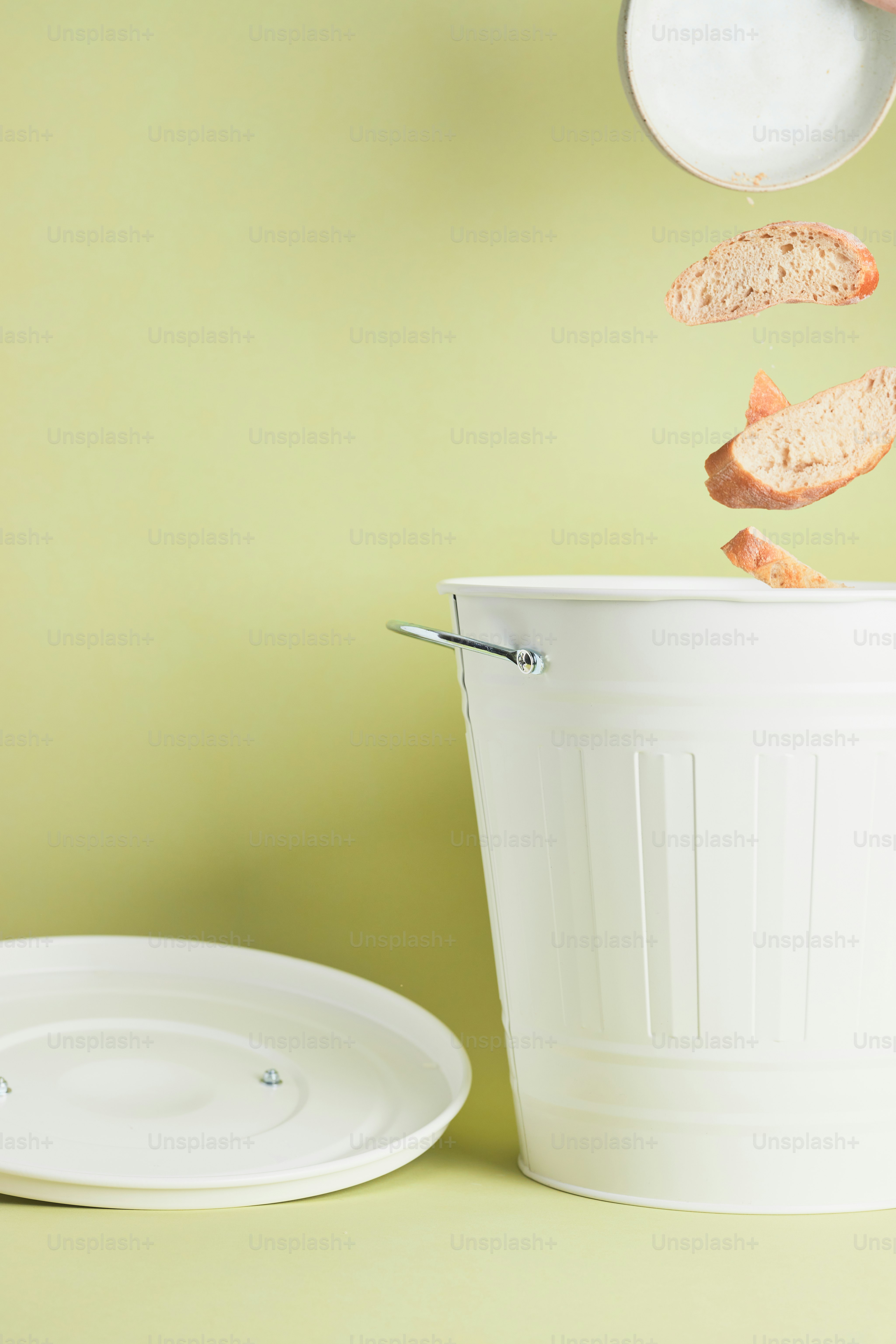 A person is tossing bread into a bucket