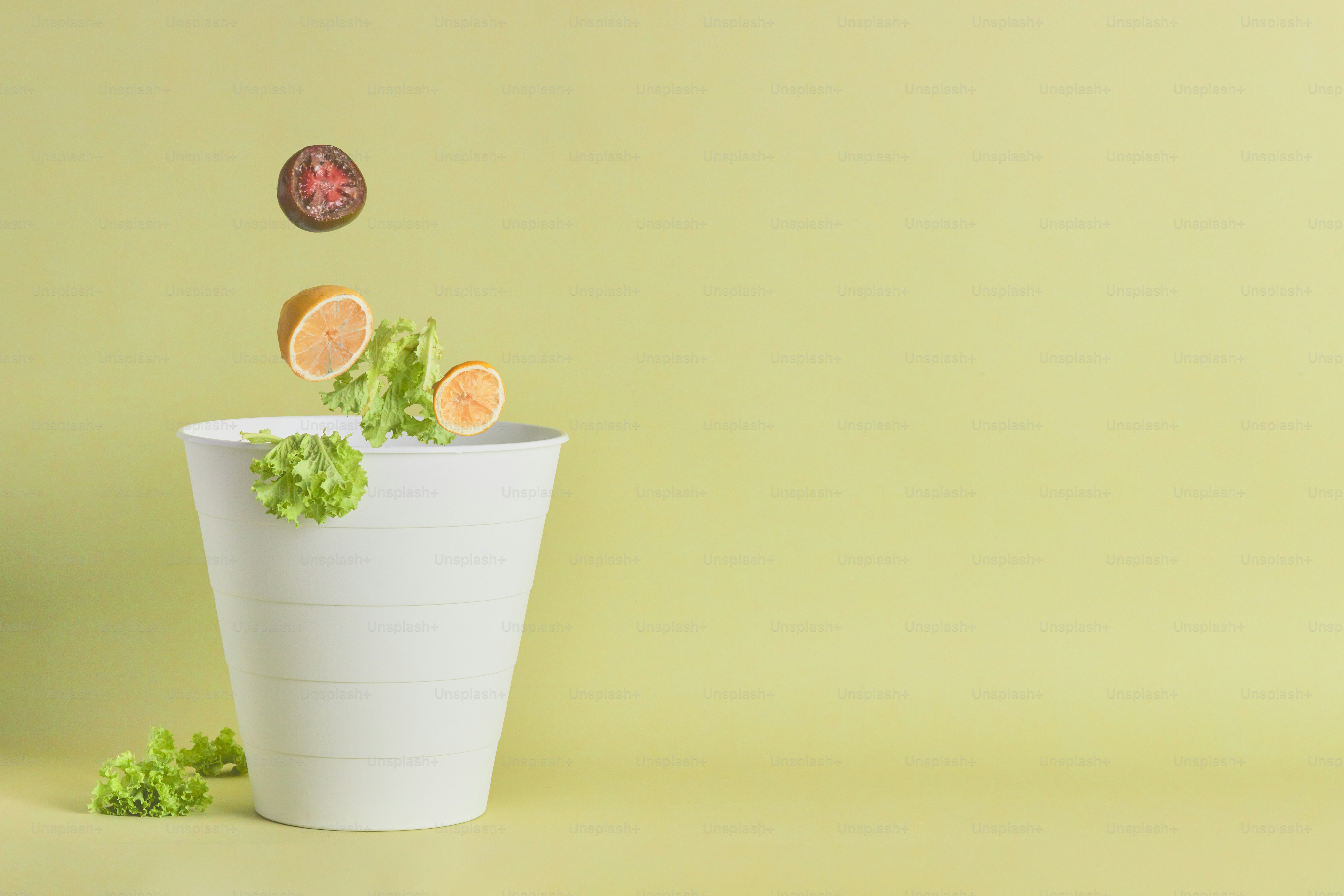 A white vase filled with lettuce and orange slices