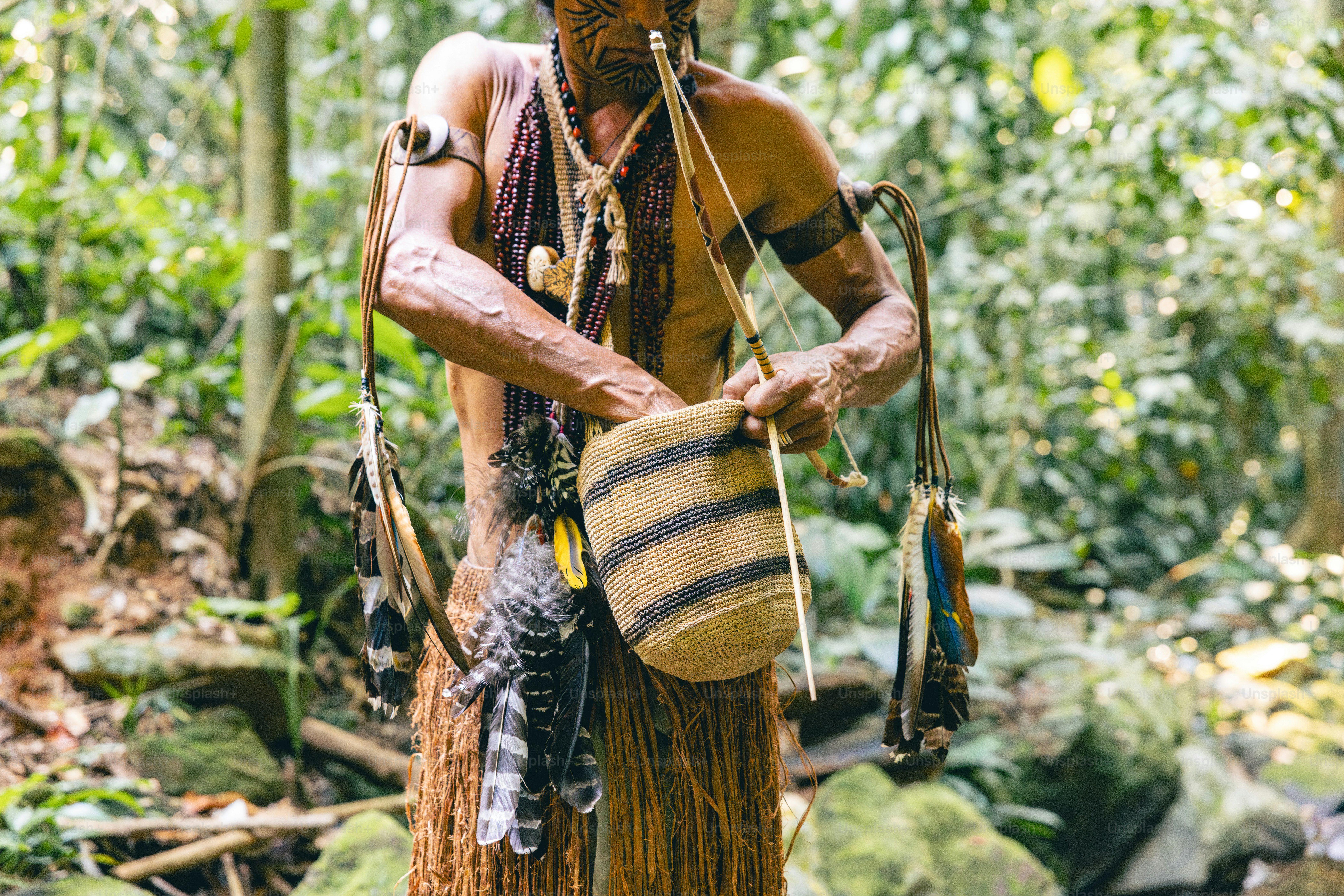 A native american man in the woods with a drum
