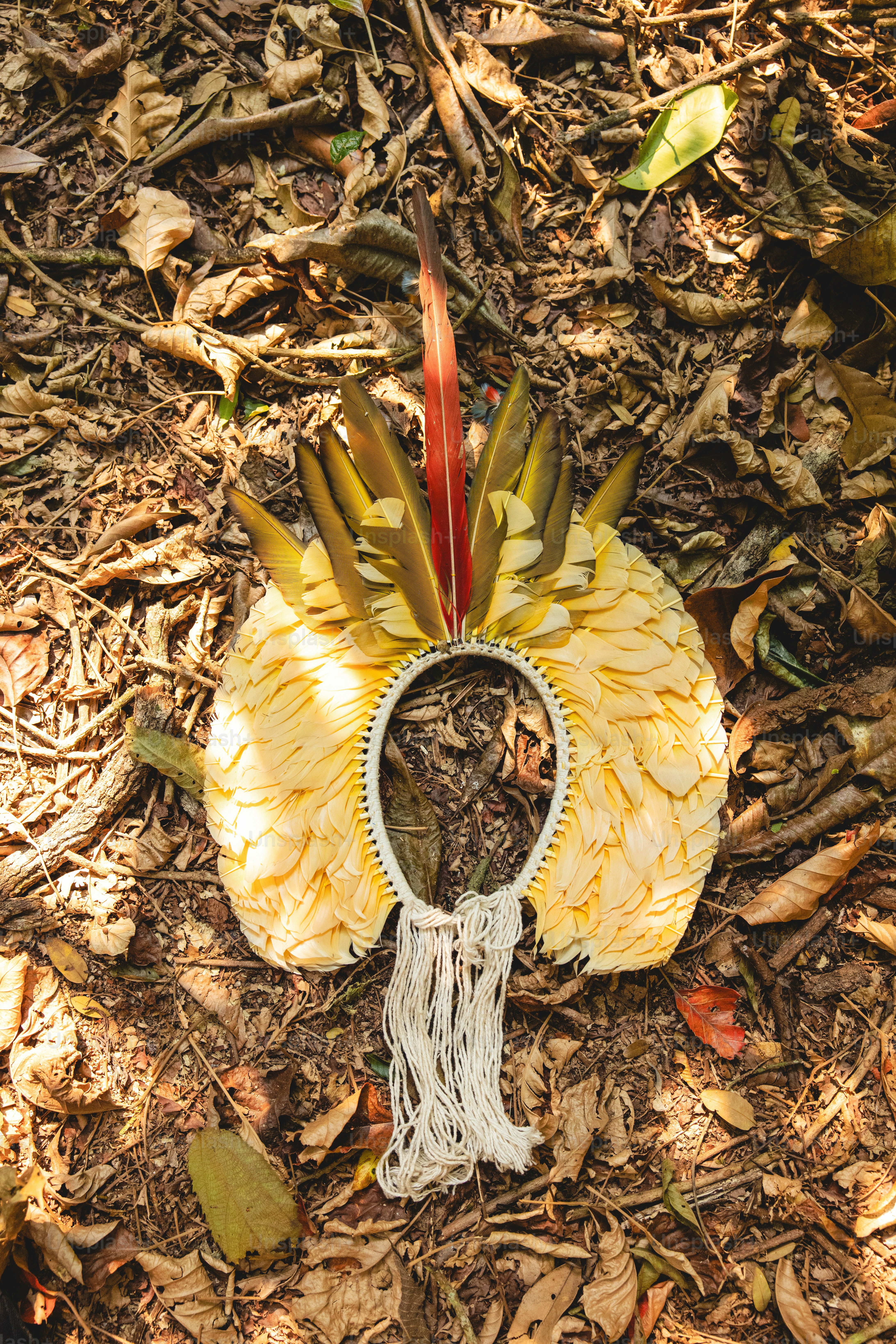 A yellow and white headdress laying on the ground