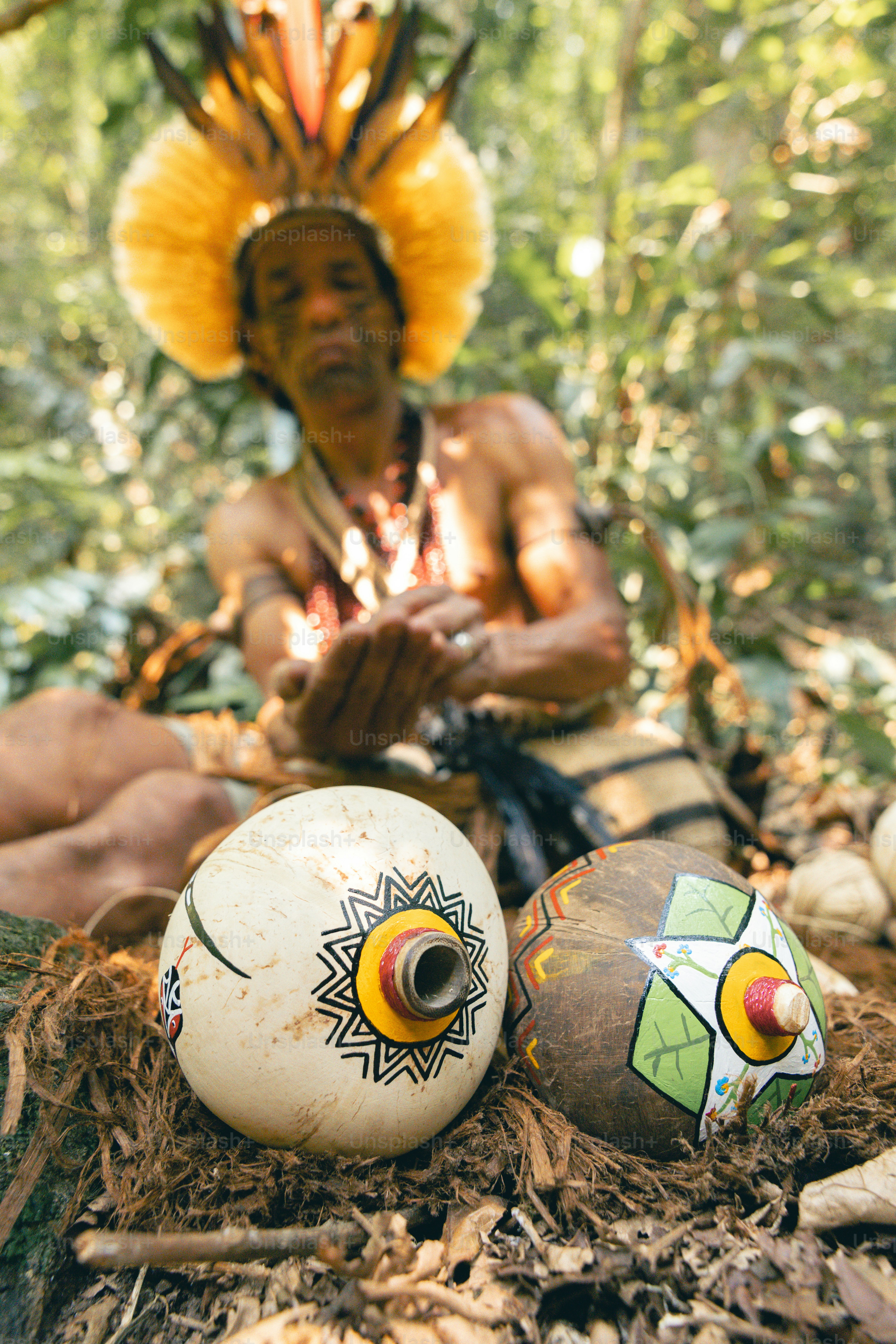 A man sitting on the ground next to some balls