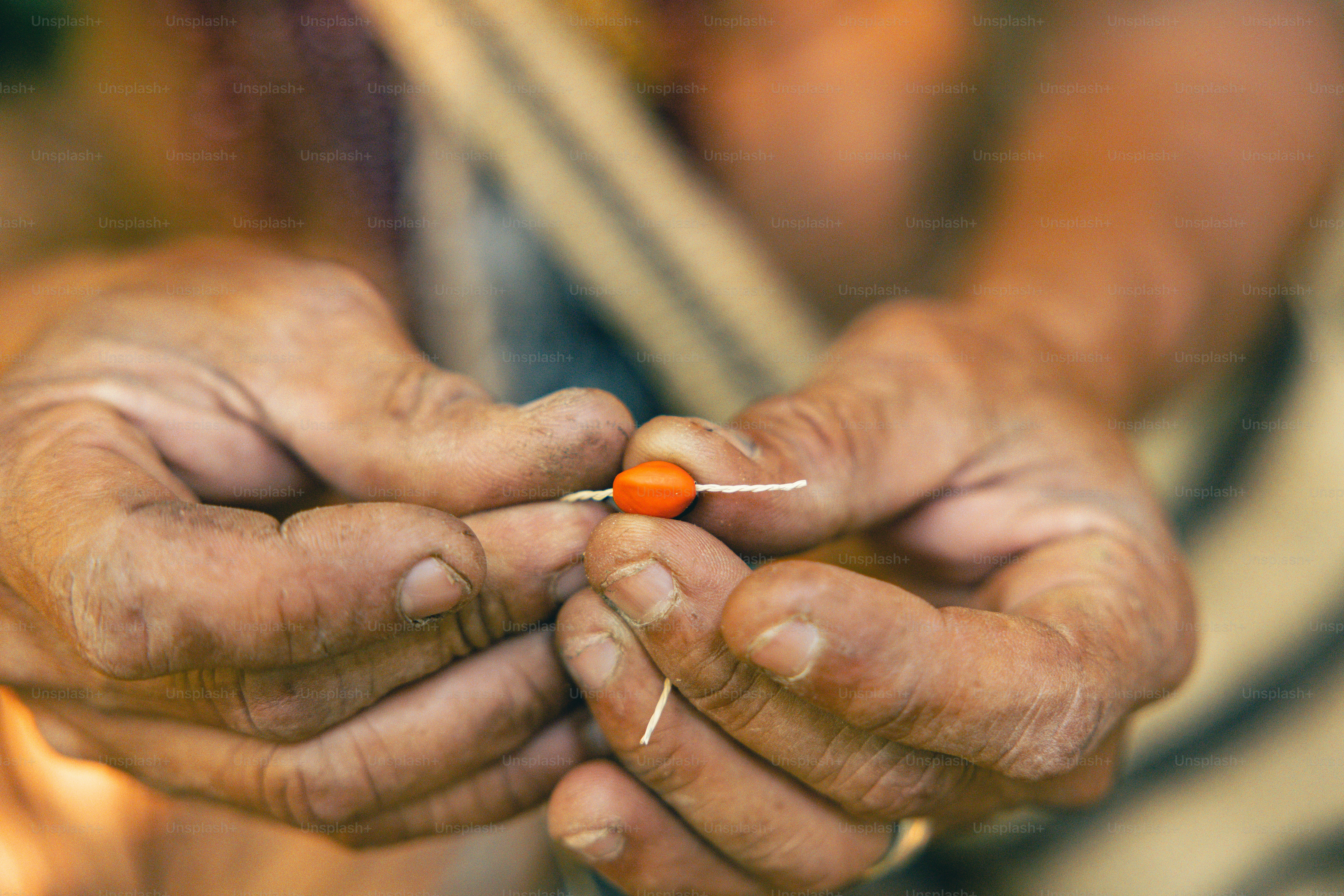 A person holding a small orange object in their hands