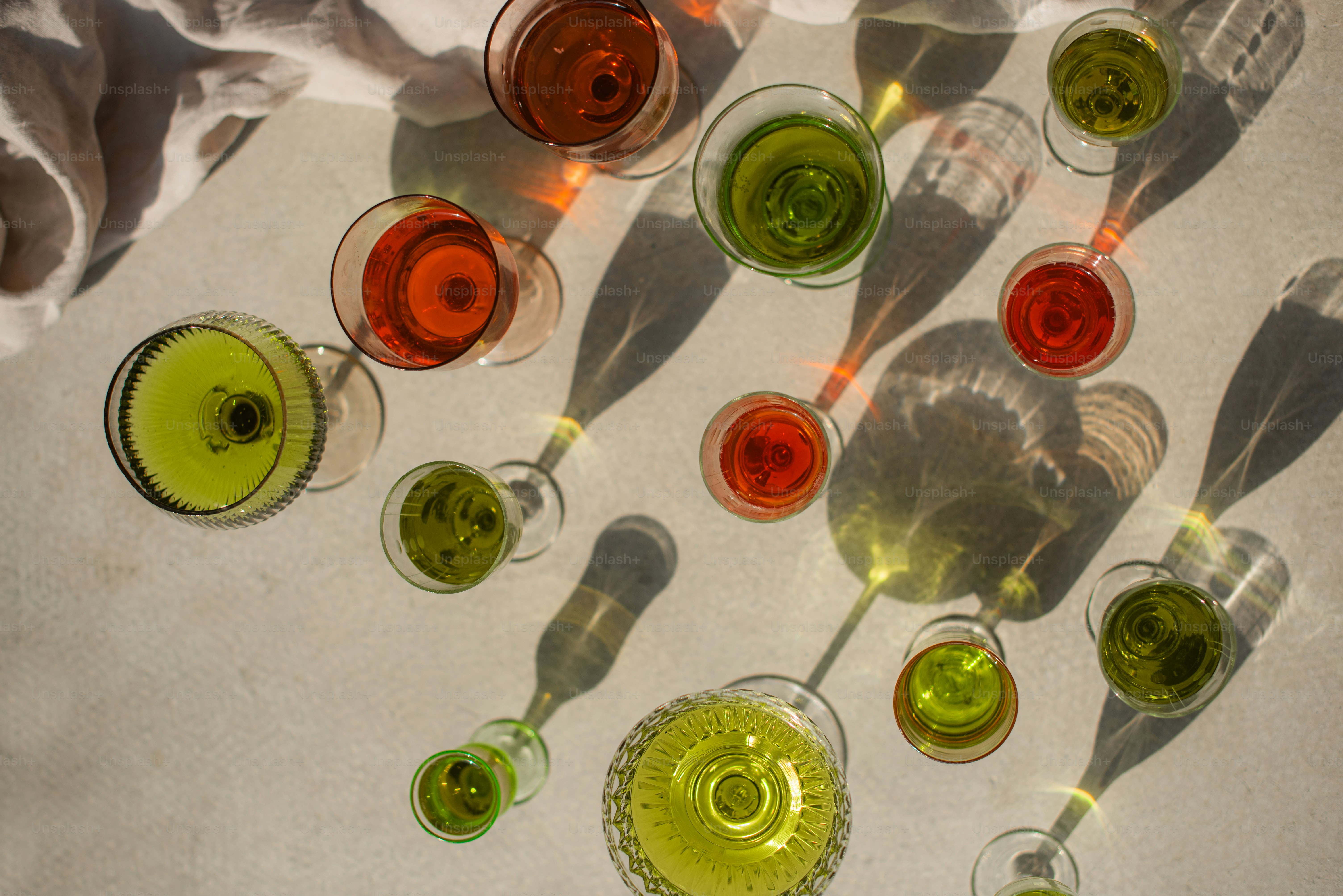 A table topped with lots of glasses filled with liquid