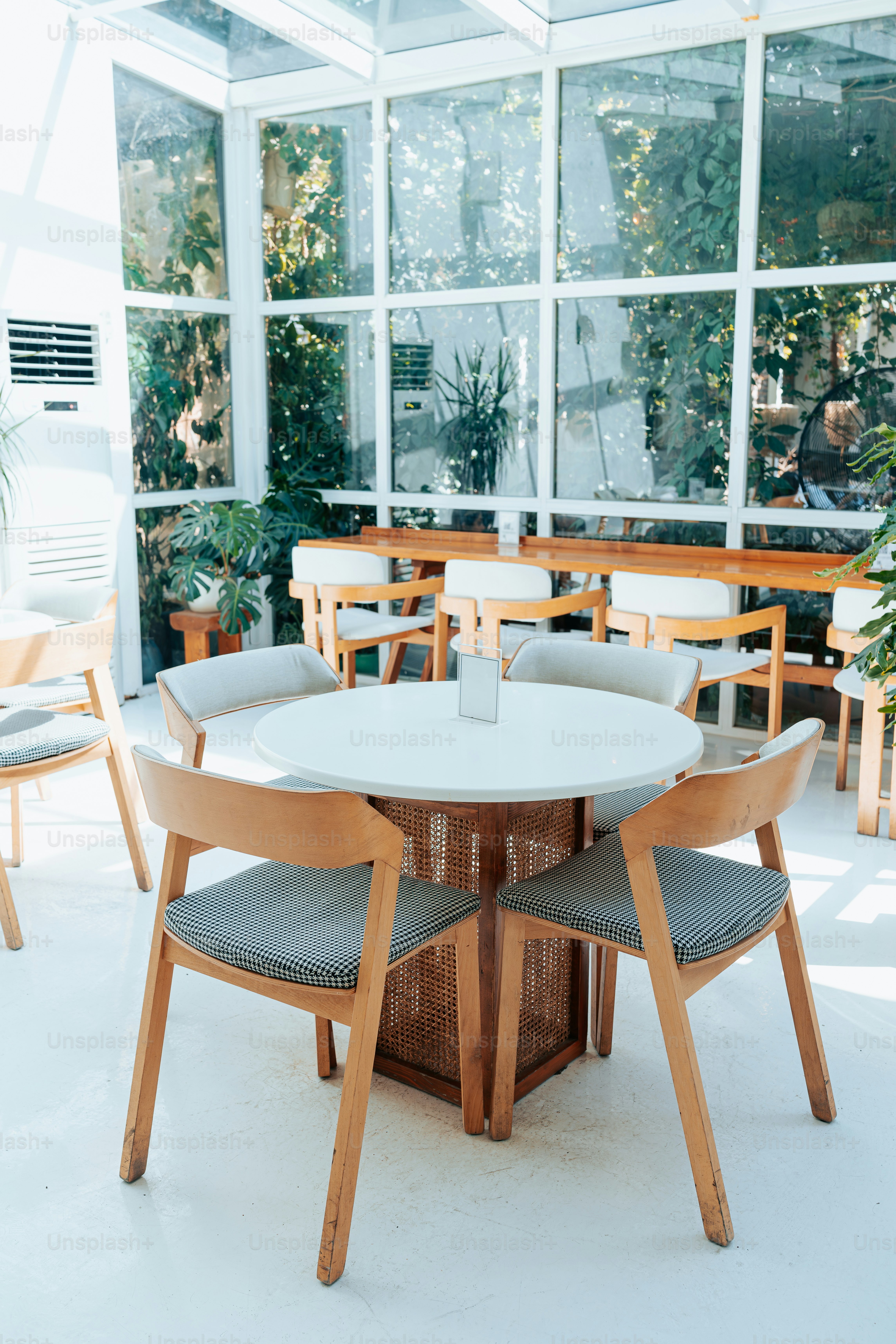 A table and chairs in a room with large windows photo – Restaurant ...