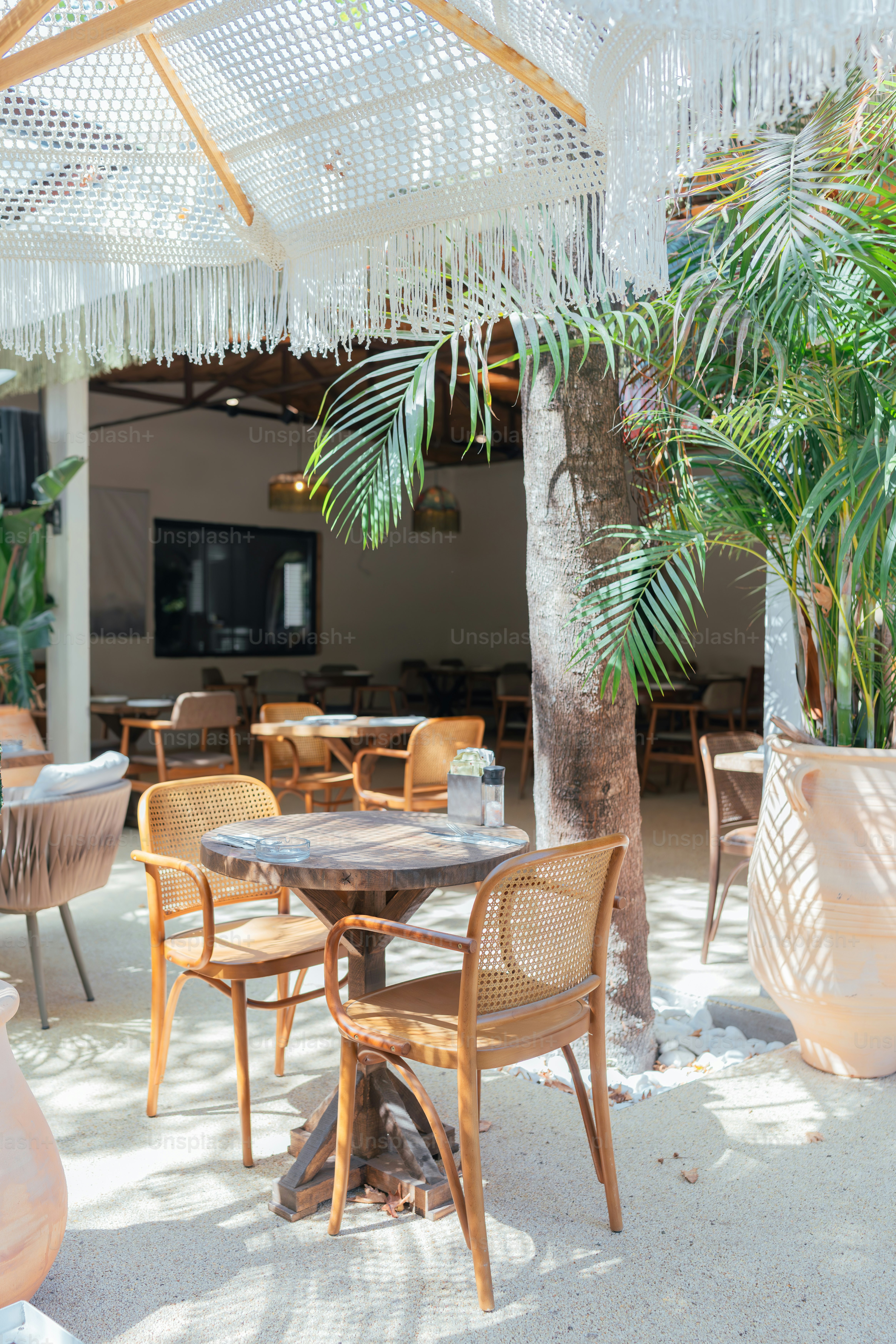 A table and chairs under a white umbrella