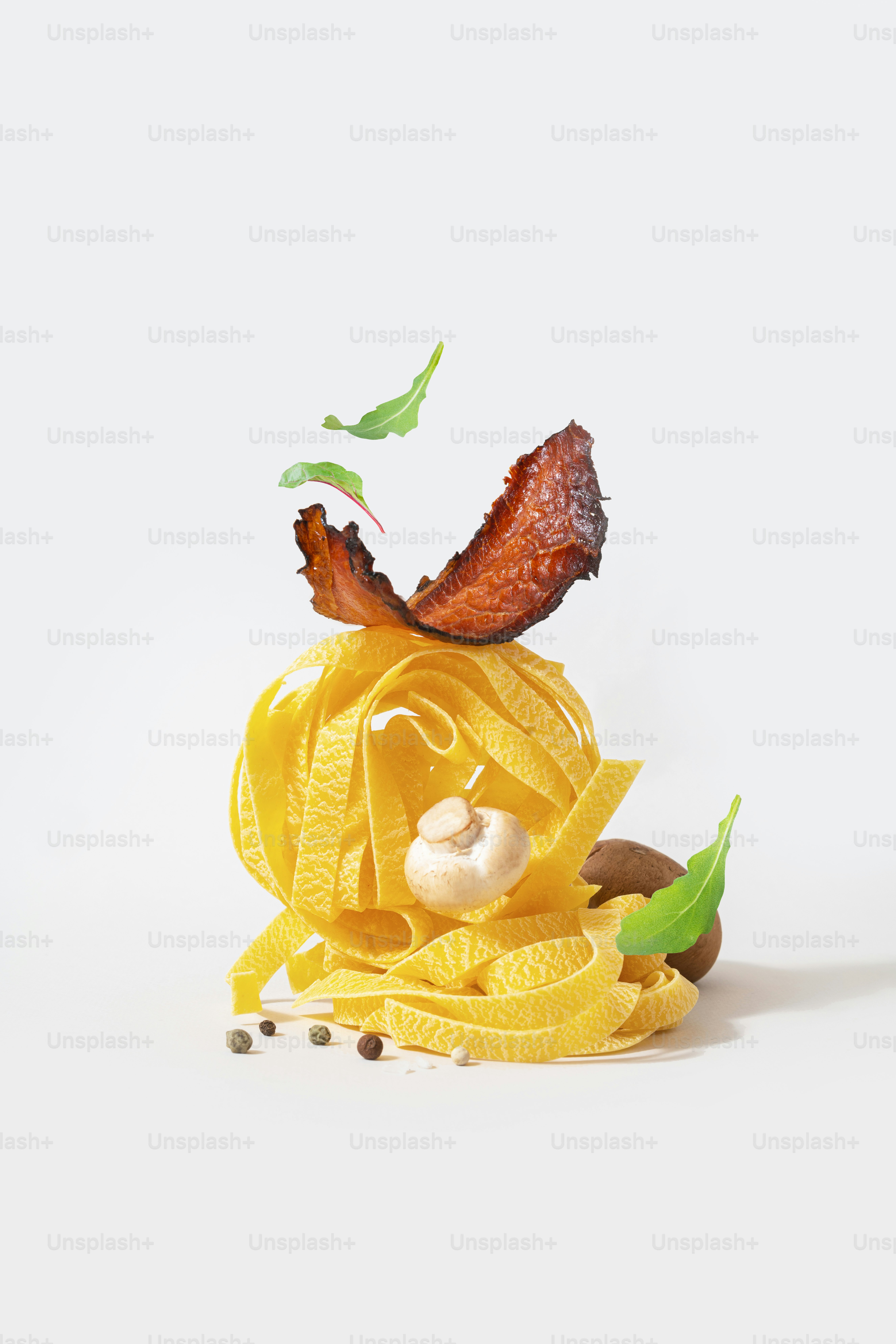 A pasta dish with bacon on top of it