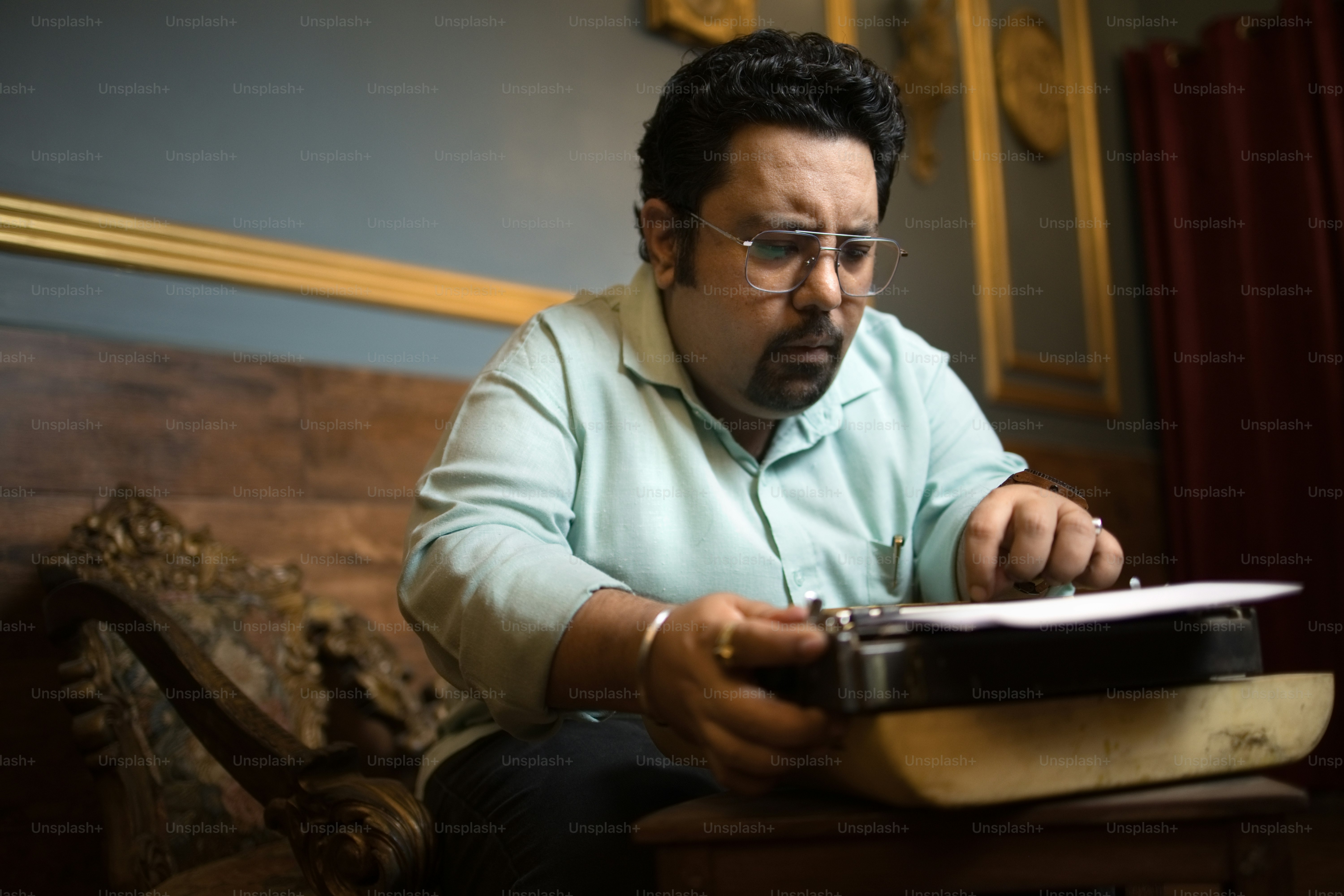 A man sitting on a couch looking at a book