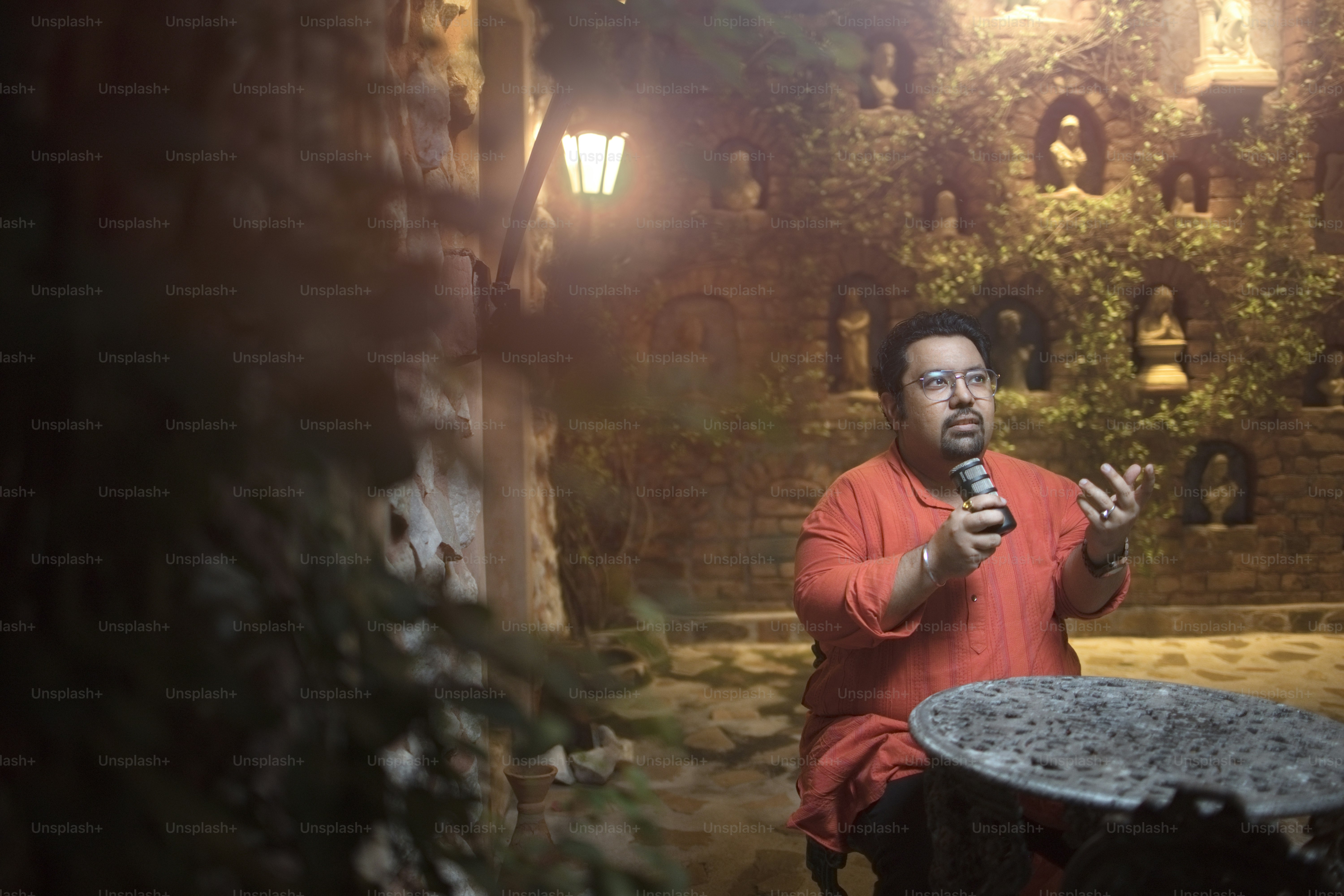 A man sitting at a table holding a microphone