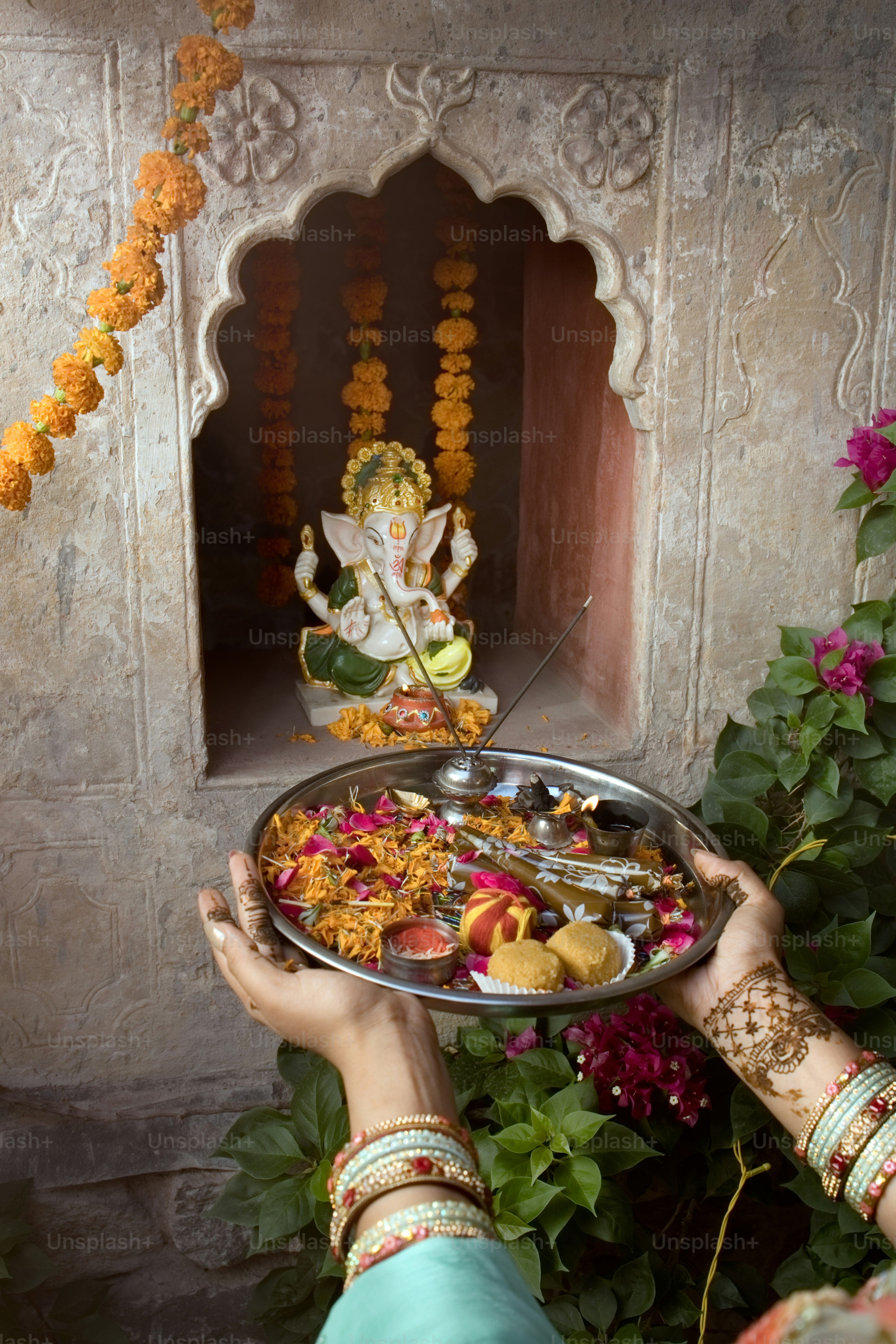 A woman holding a tray of food in front of a statue