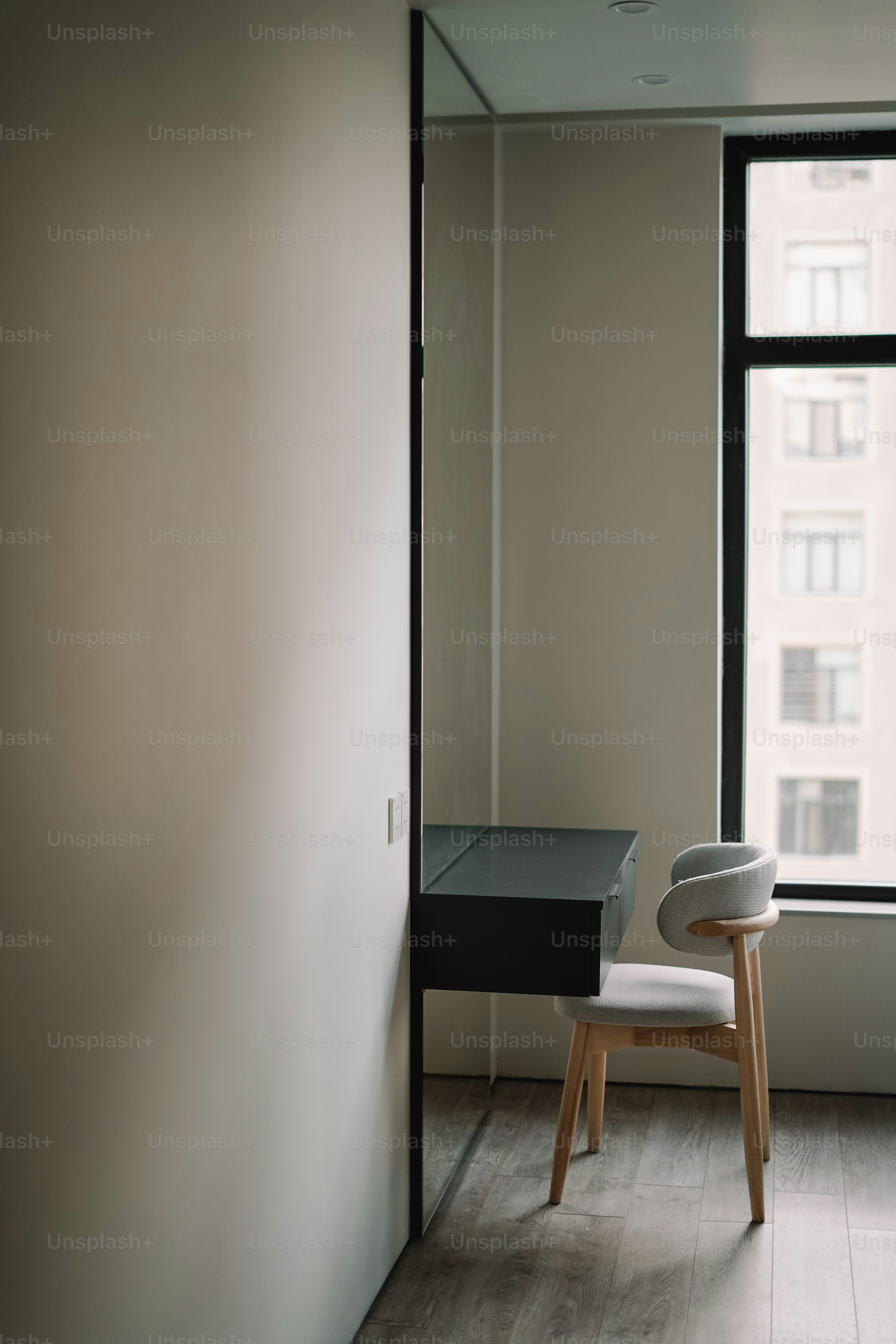 A room with a chair and a desk in front of a window photo ...