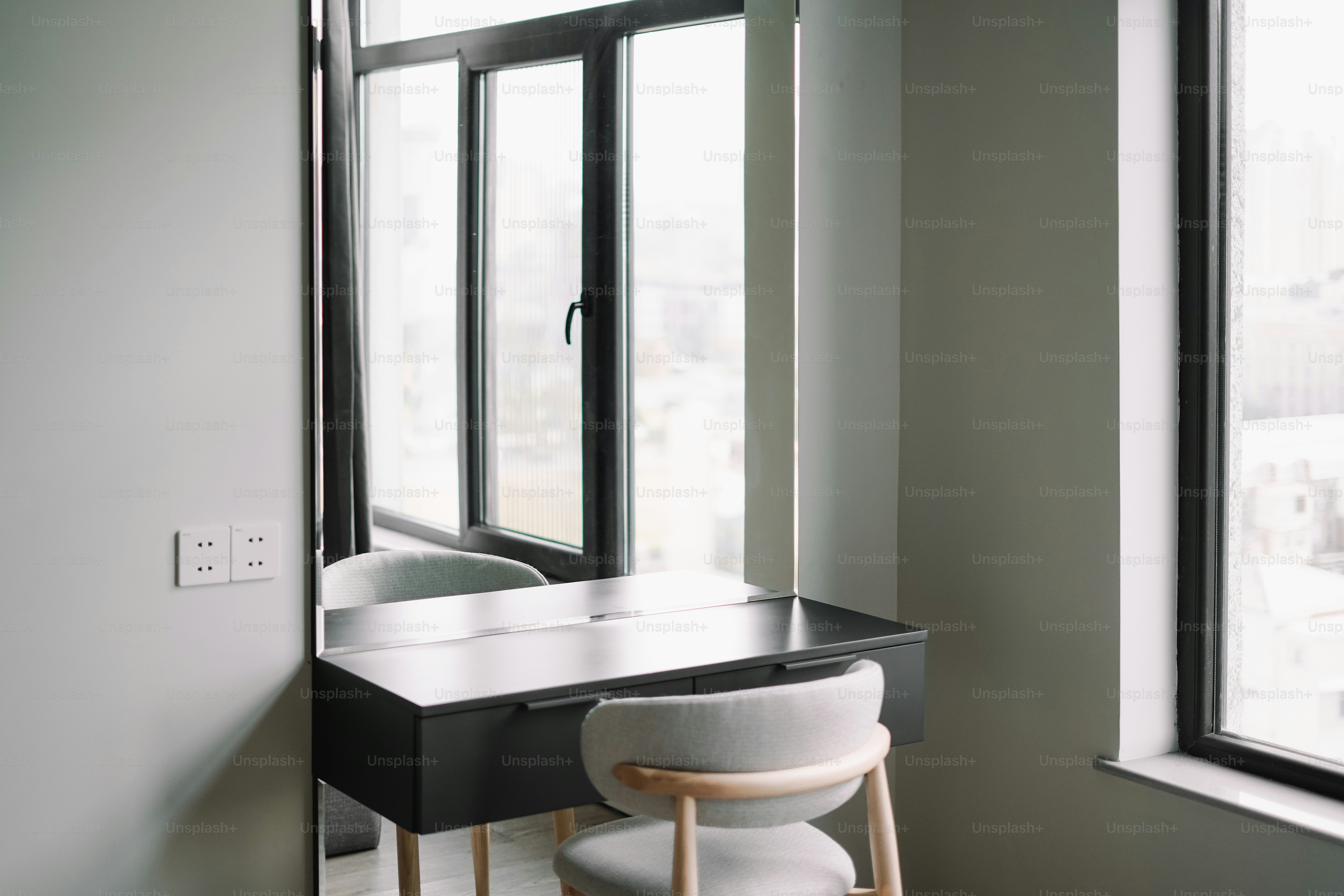 A room with a desk, chair, and window
