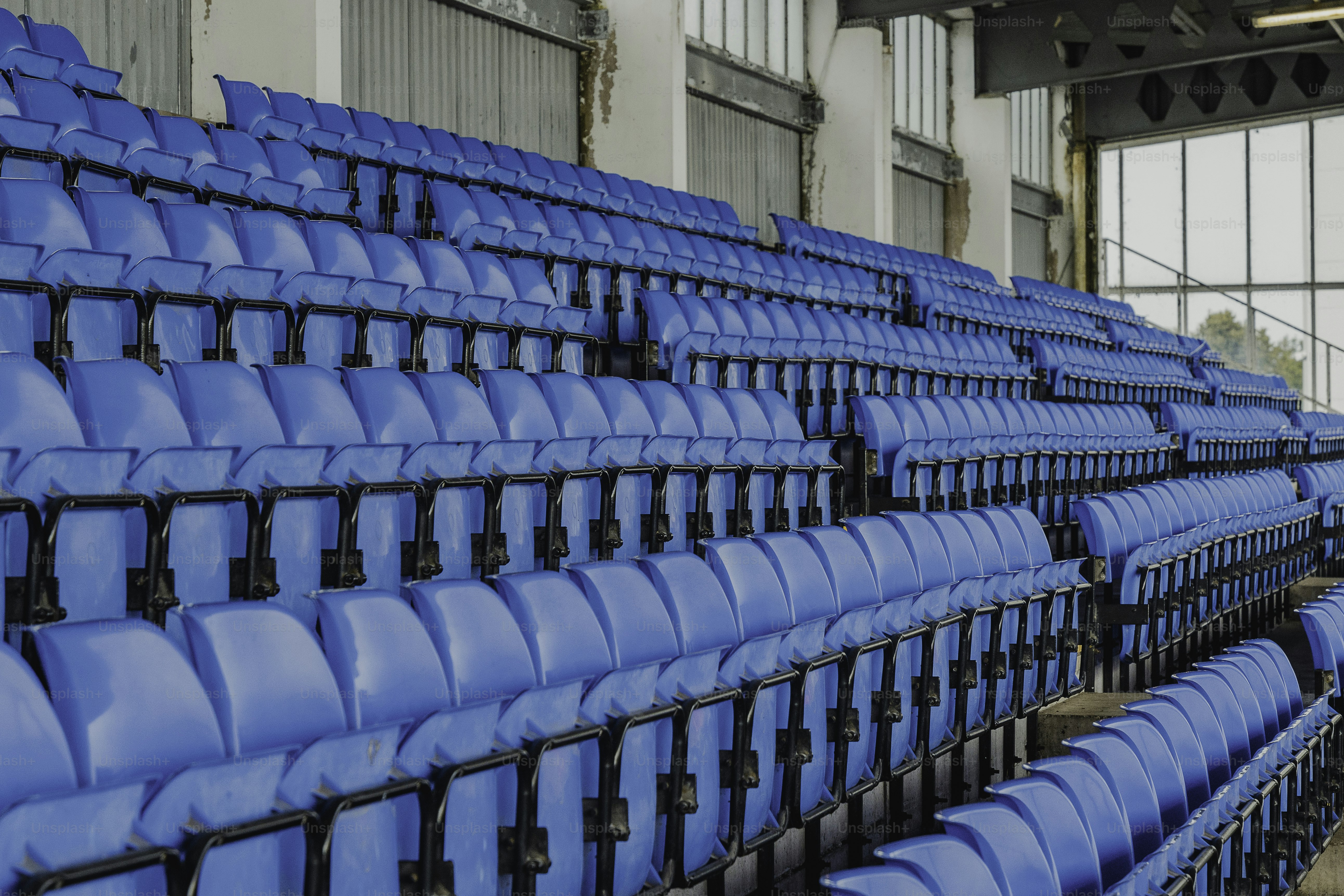 A row of blue seats sitting inside of a building