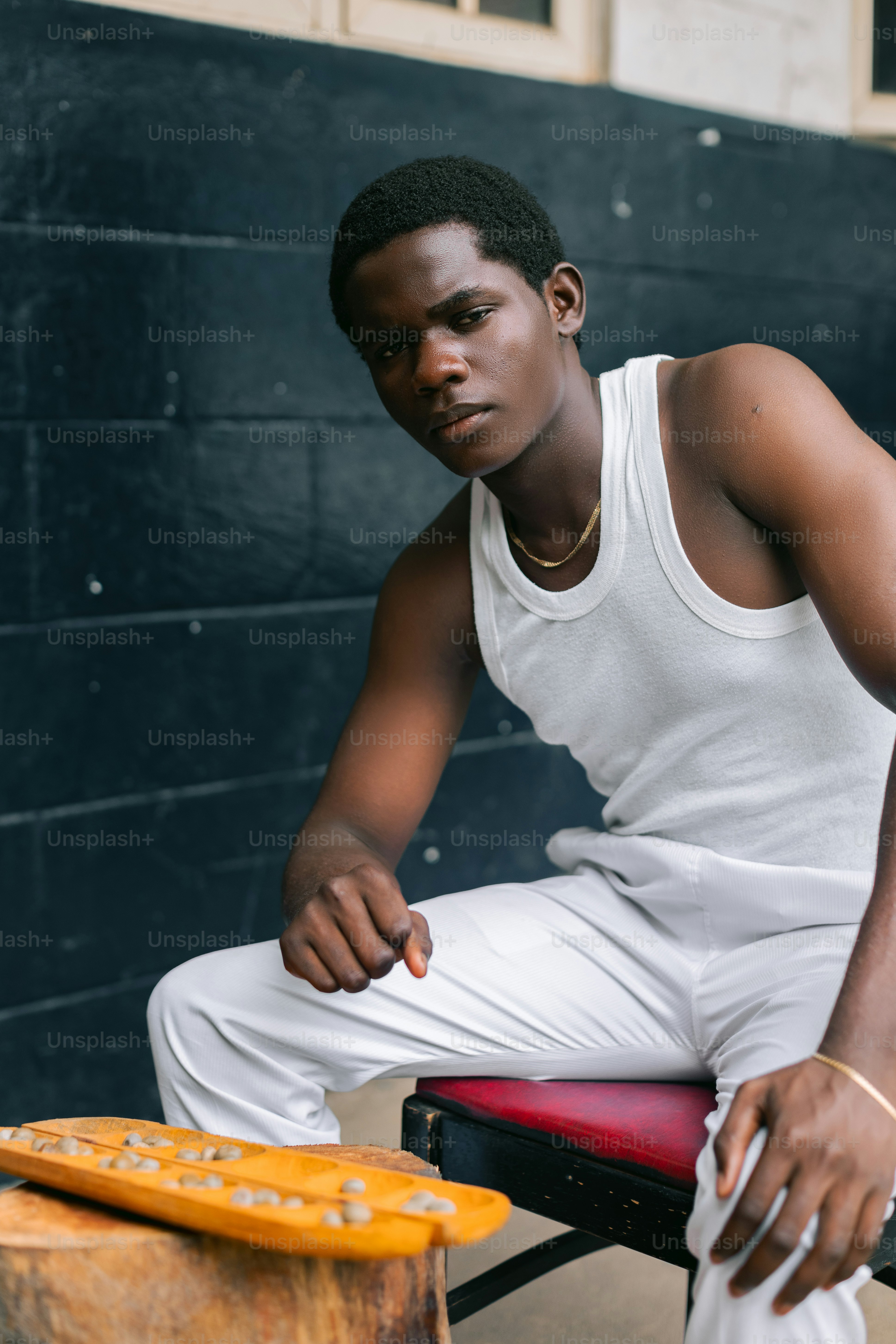 A man sitting on a chair next to a piece of wood
