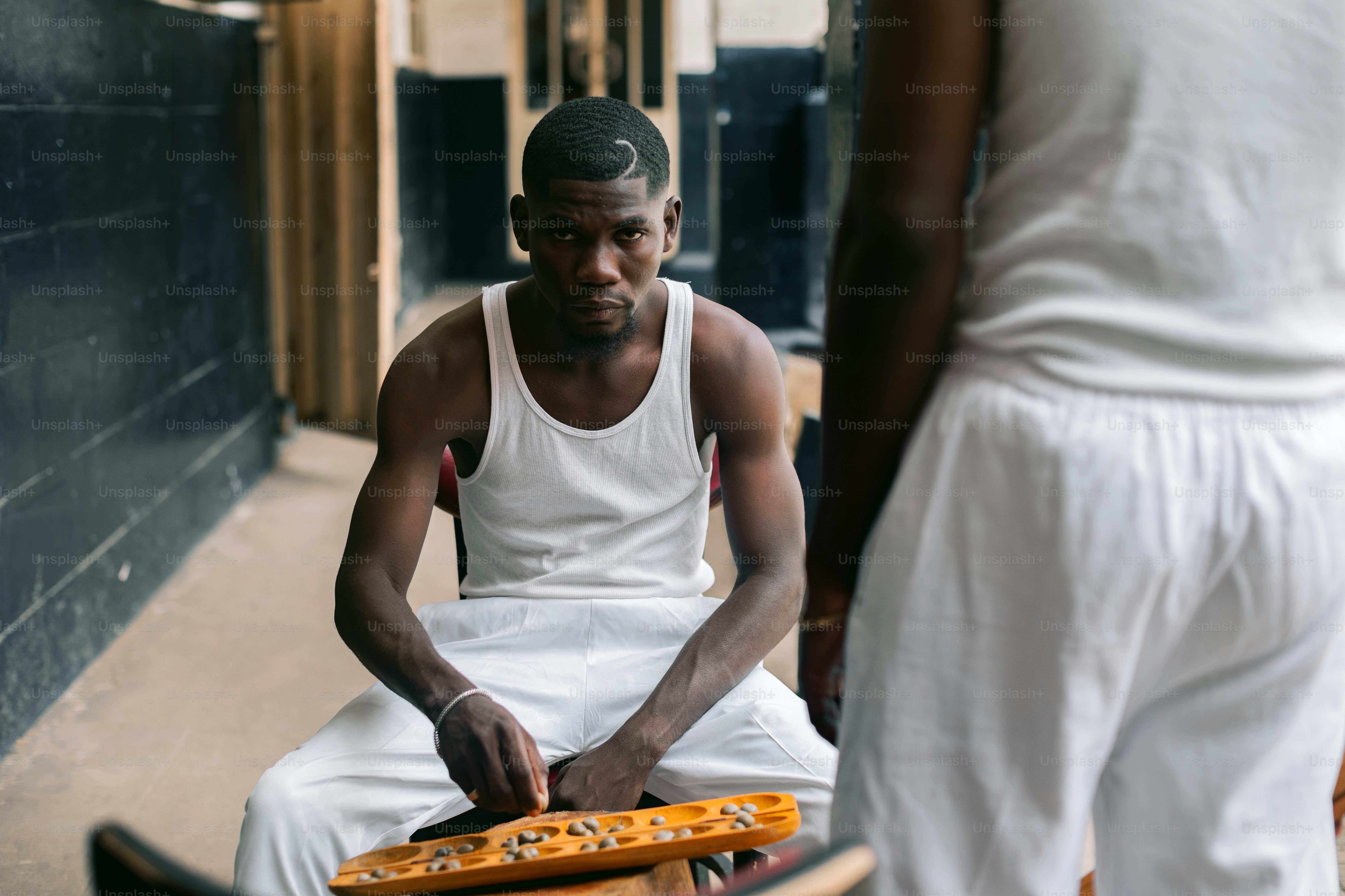 A man sitting on top of a bench holding a tennis racquet