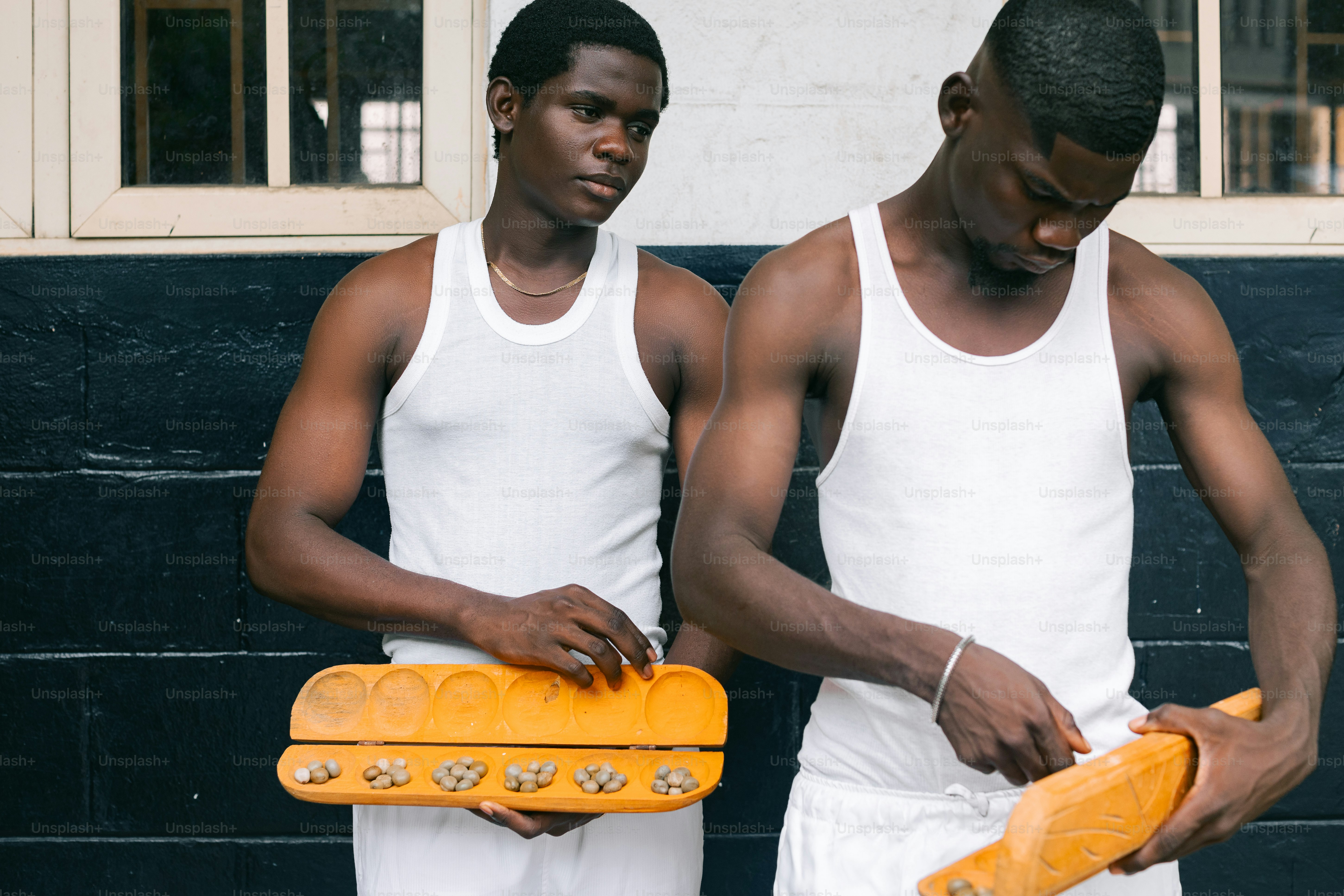 建物の前で黄色いスケートボードを持った2人の若者