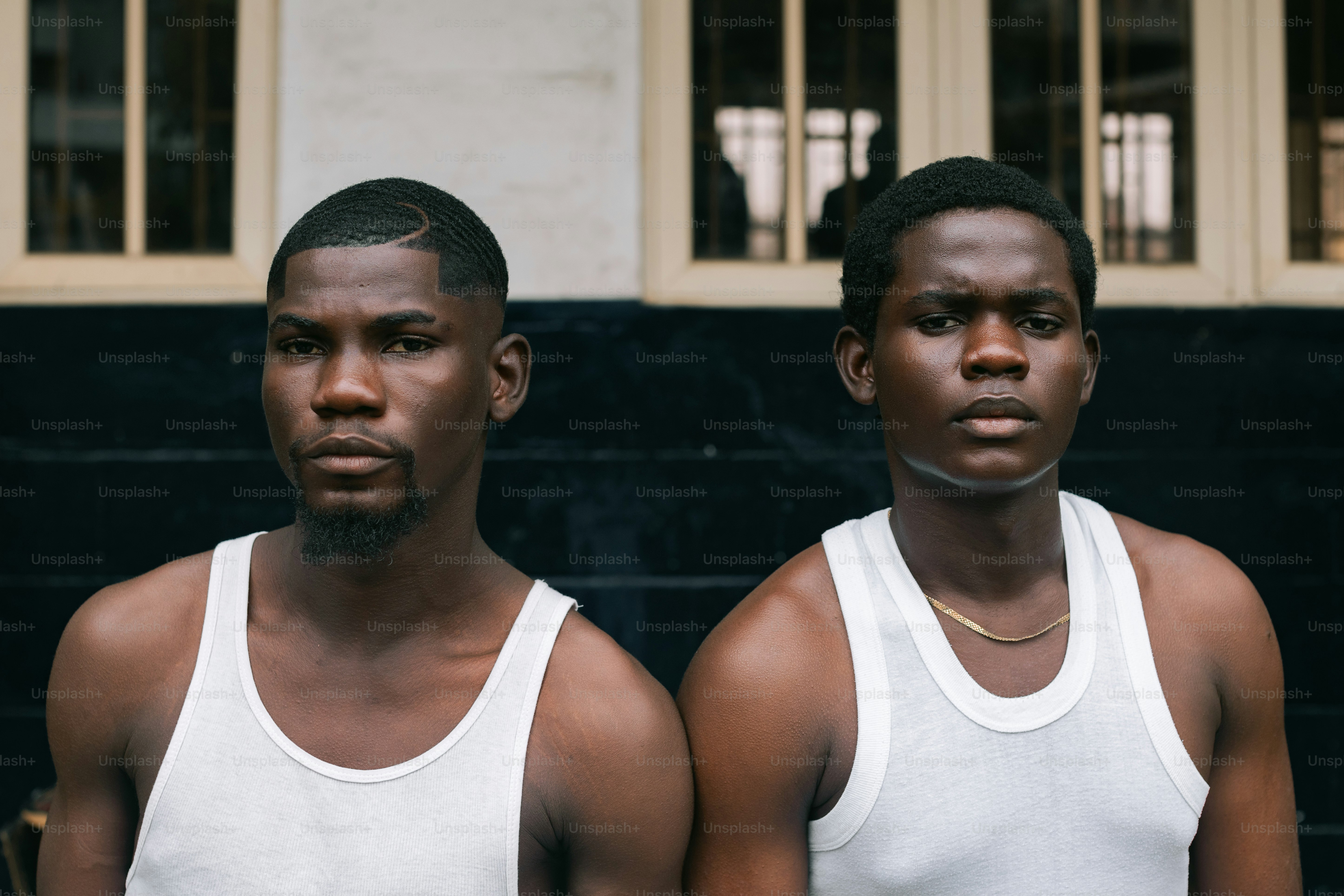 Two men standing next to each other in front of a building photo ...