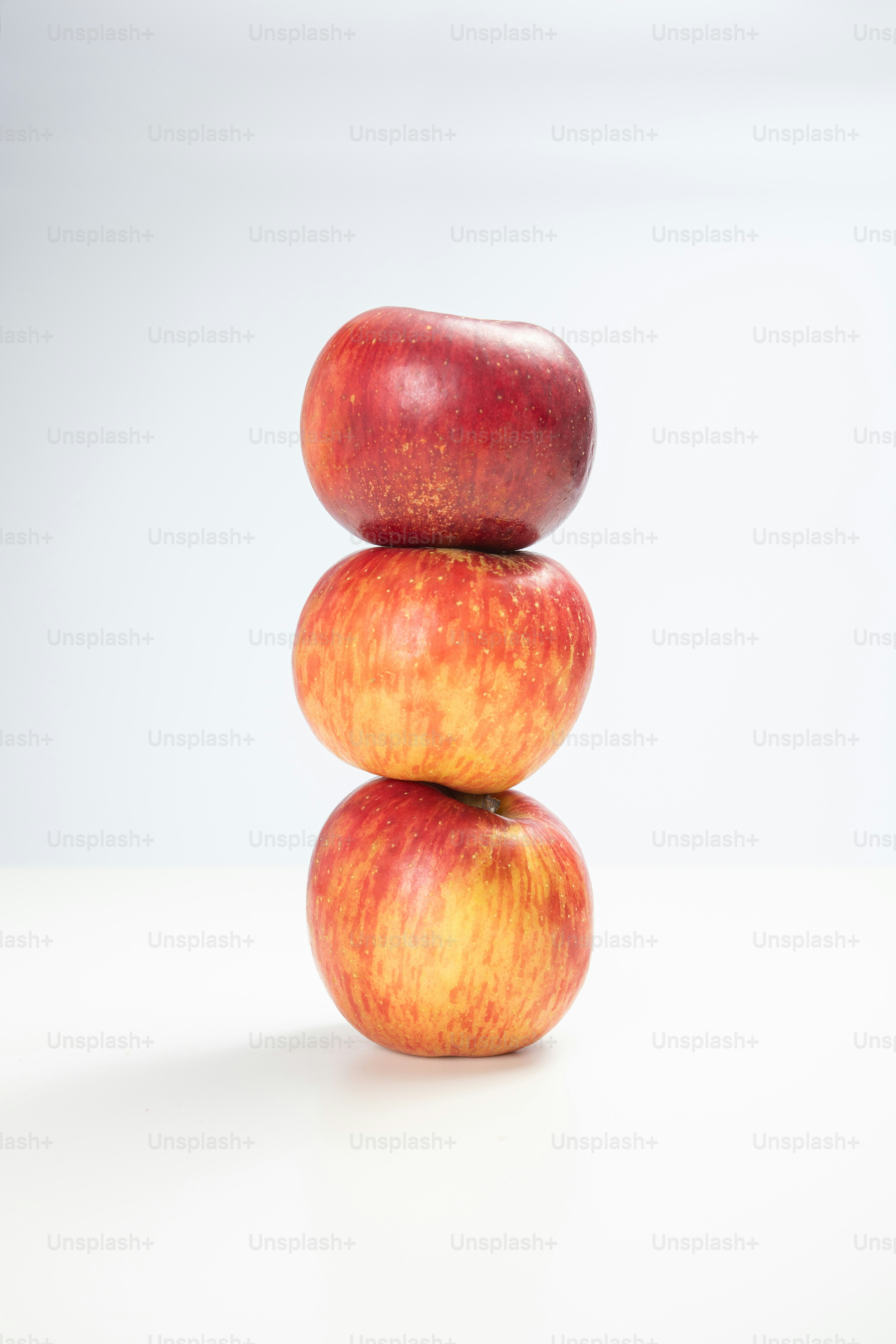 Uma pilha de três maçãs sentadas umas sobre as outras