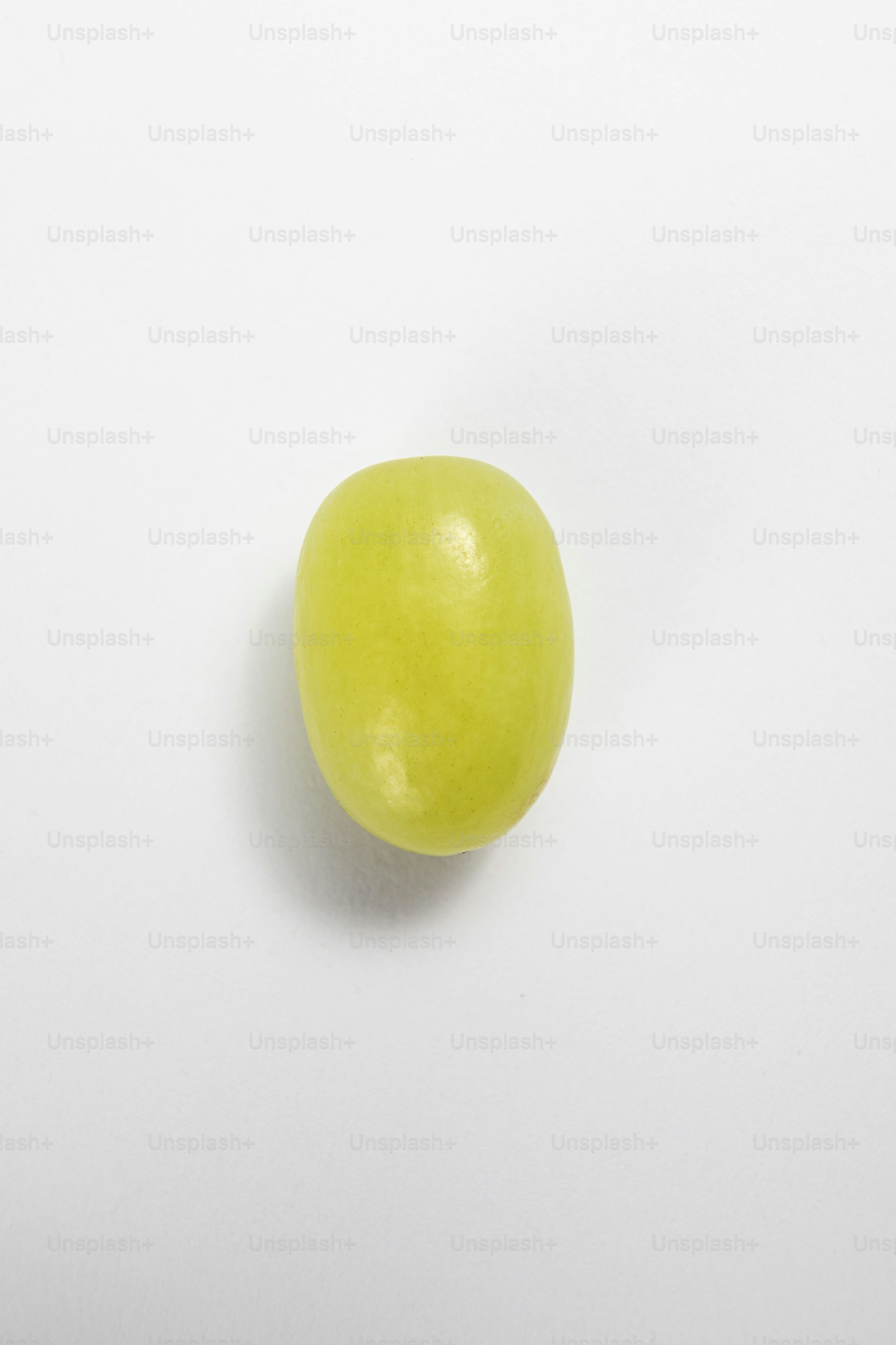 Ein grüner Apfel sitzt auf einem weißen Tisch