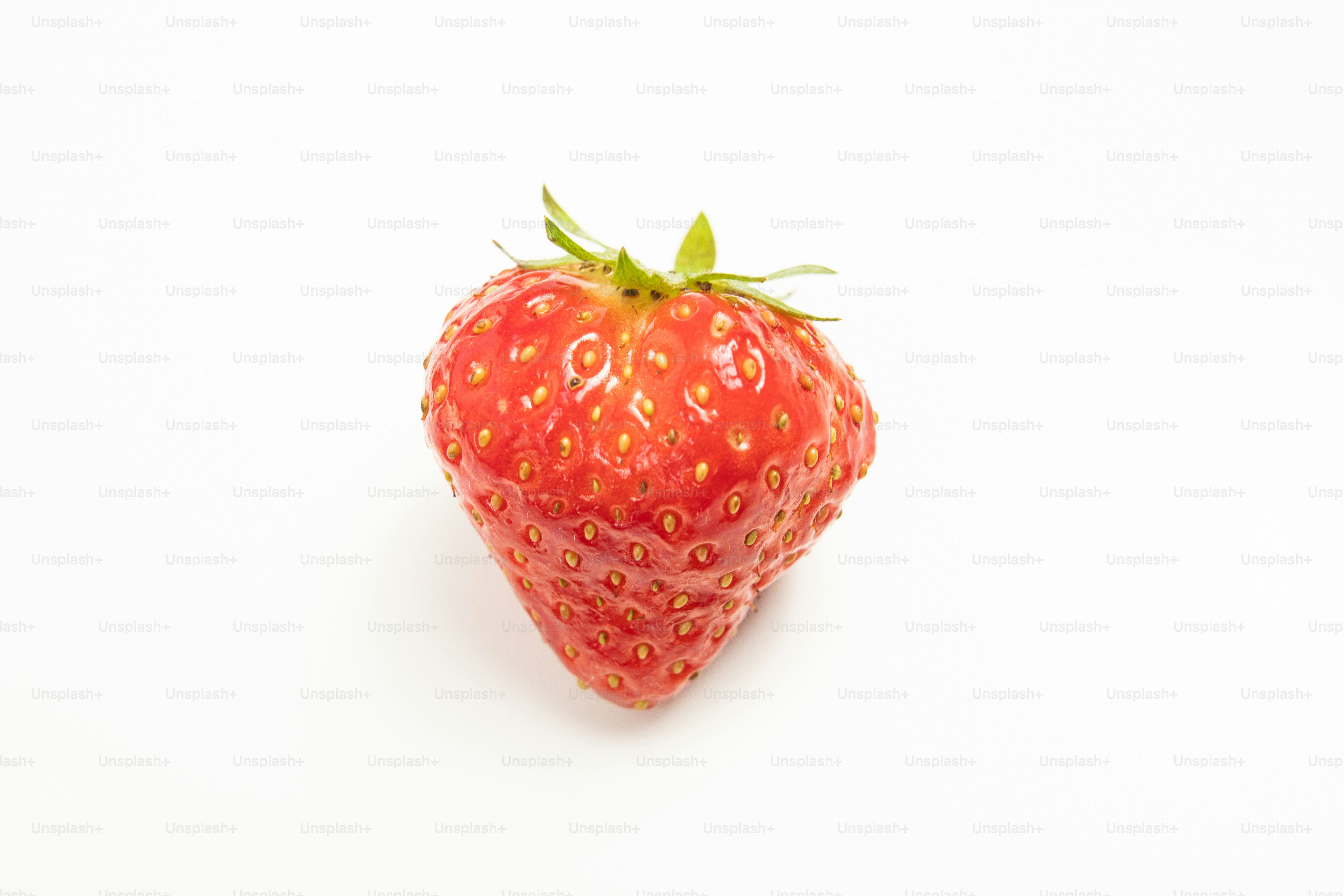 A close up of a strawberry on a white background