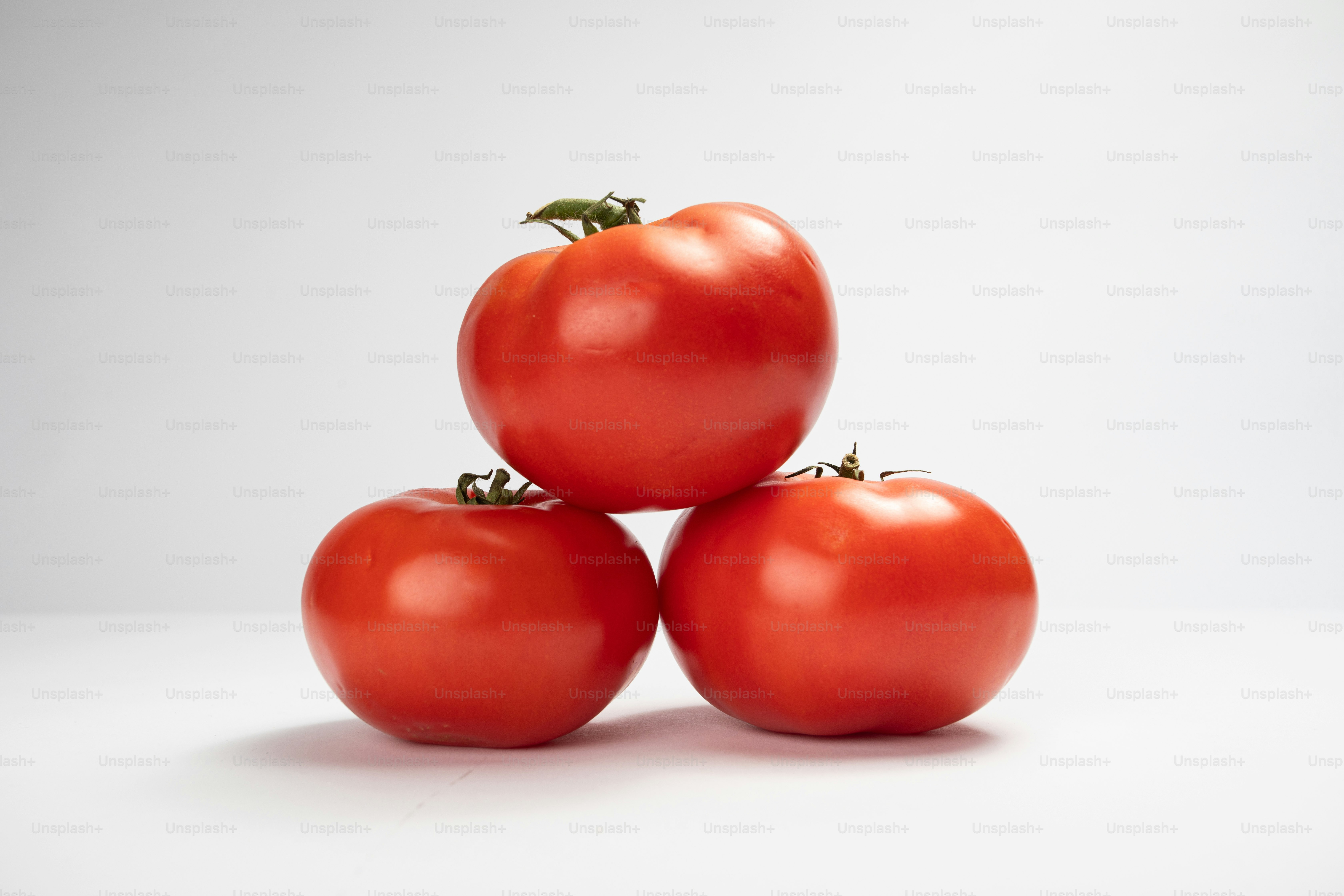 Eine Gruppe von vier Tomaten, die übereinander sitzen