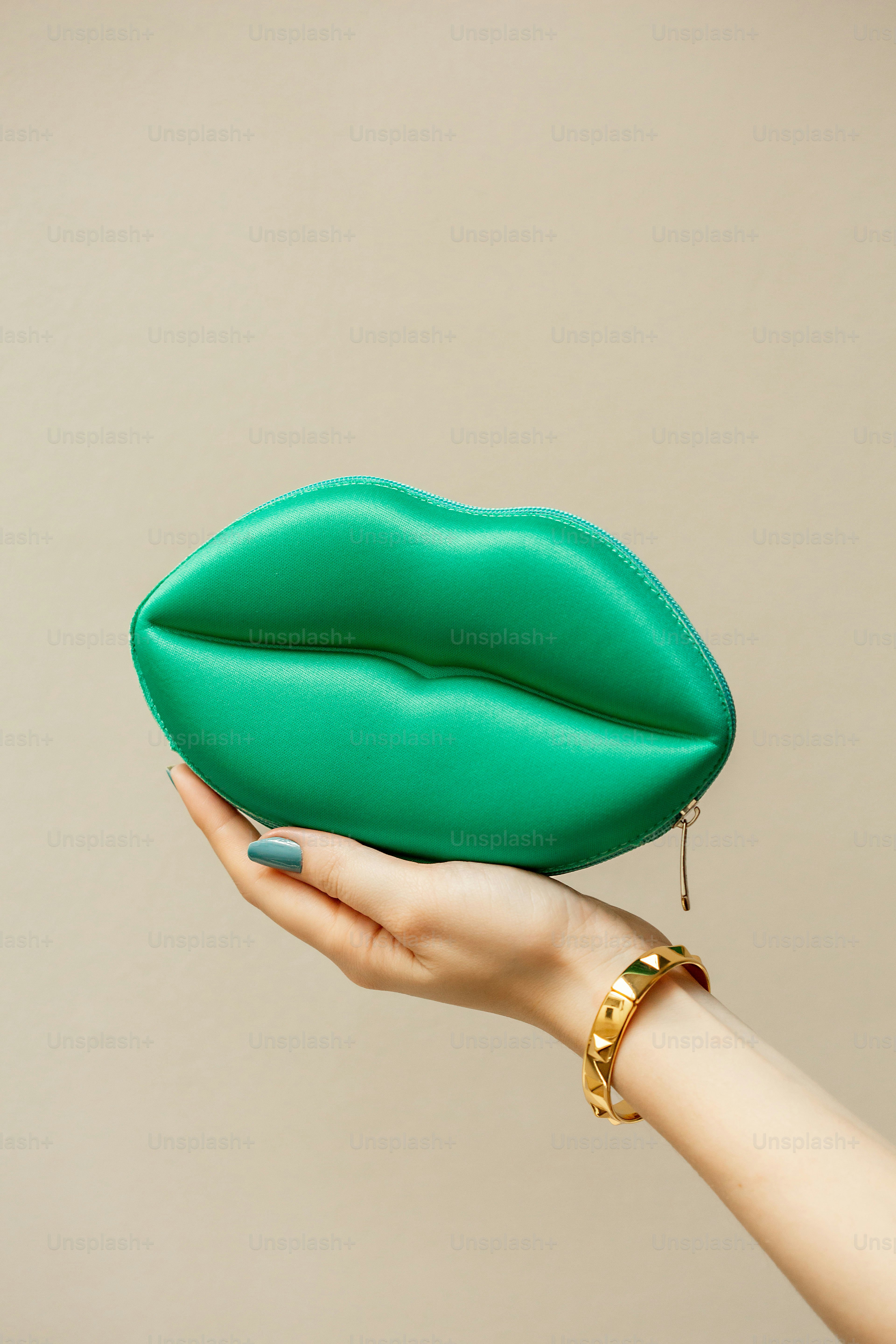 La mano de una mujer sosteniendo un bolso verde