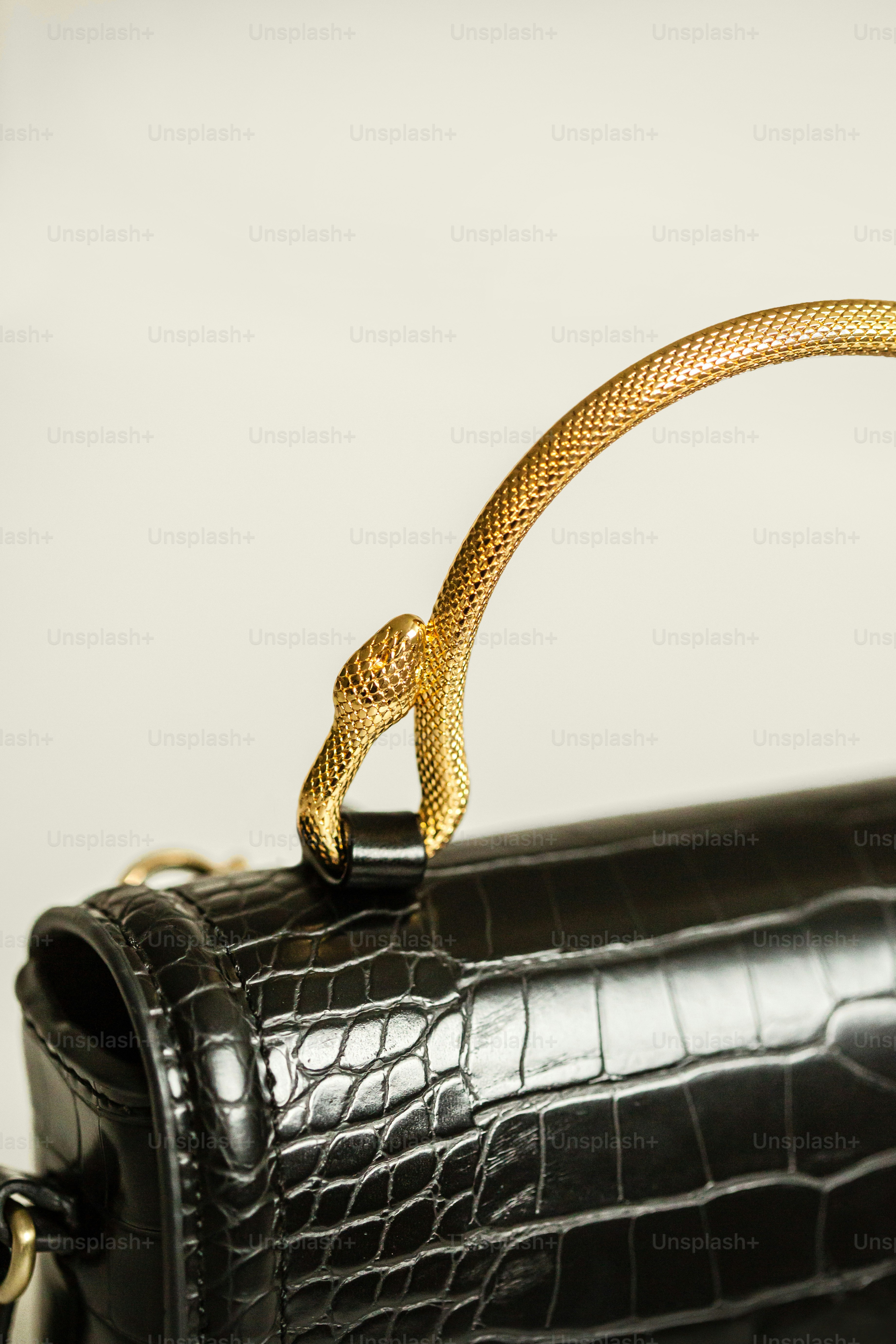 A black purse with a gold handle on a table