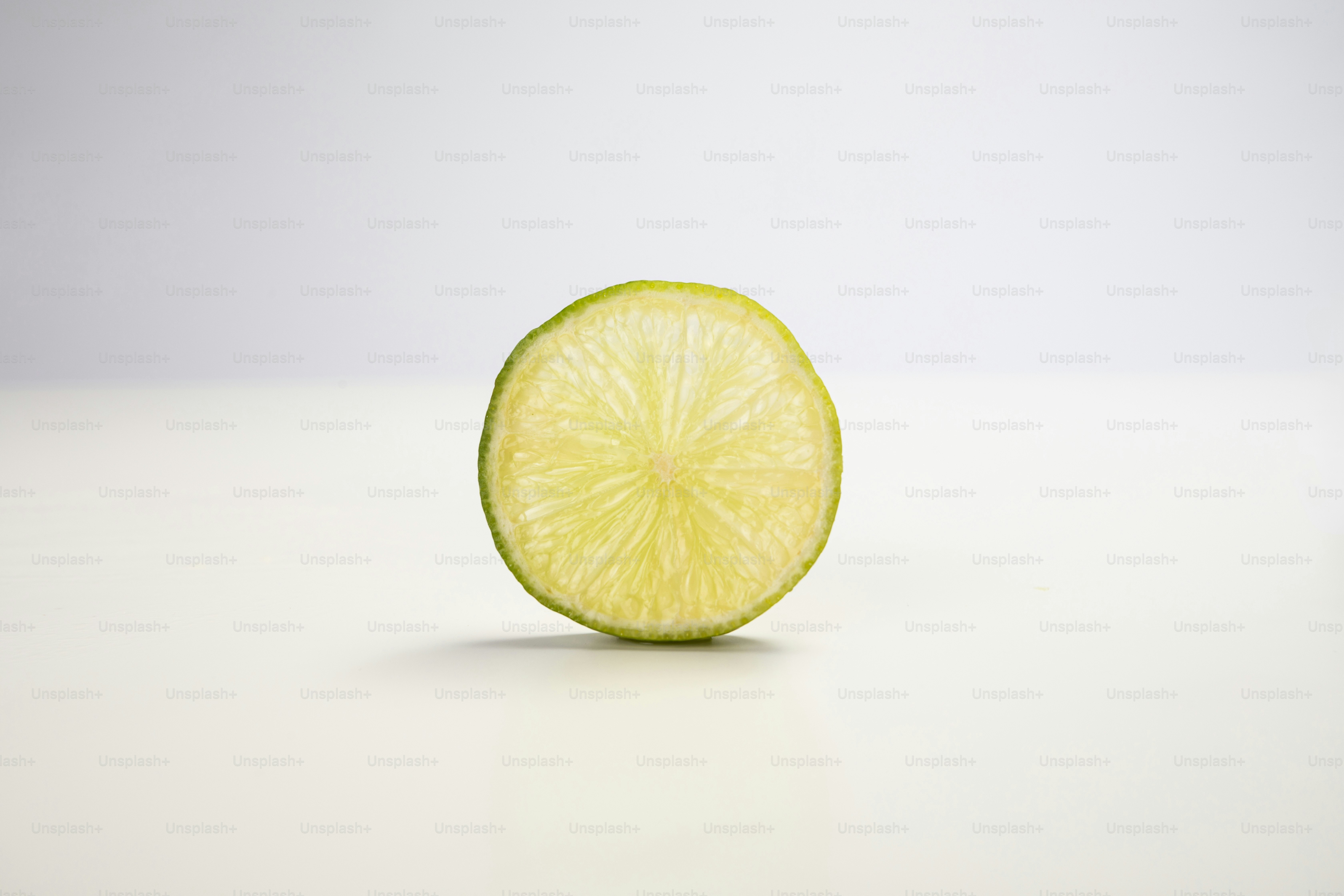 Una rodaja de lima encima de una mesa blanca